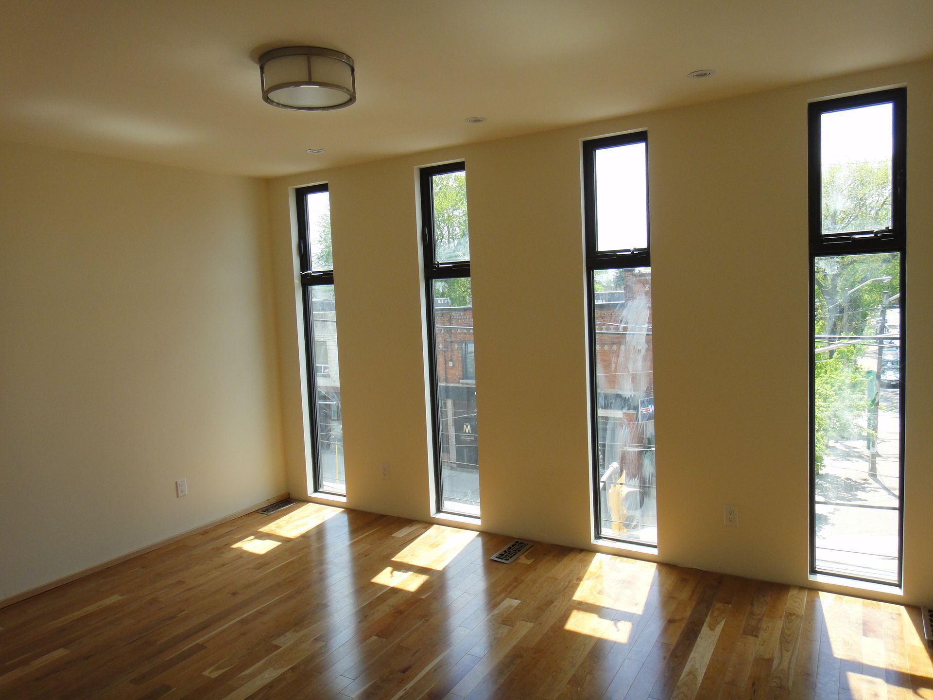 An empty room with a lot of windows and hardwood floors