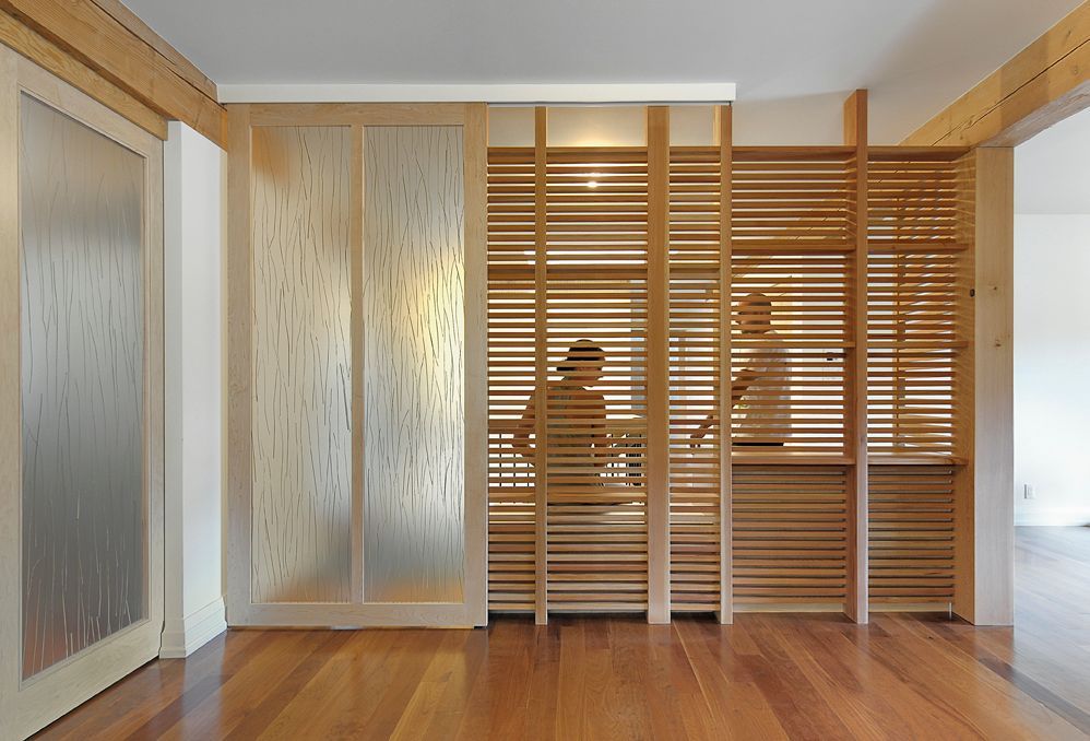 A room with a divider made of wood and glass