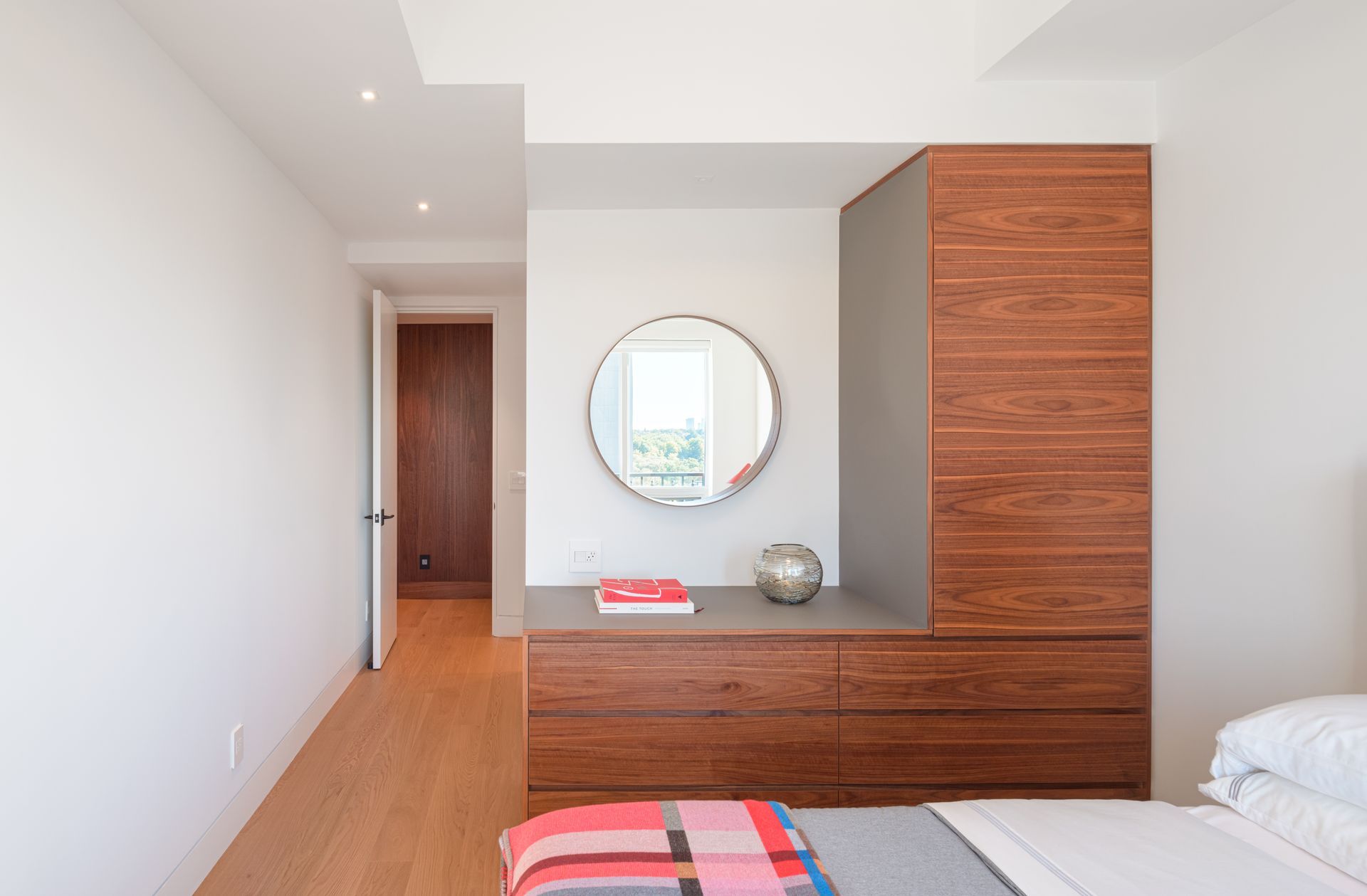A bedroom with a bed , dresser and mirror.