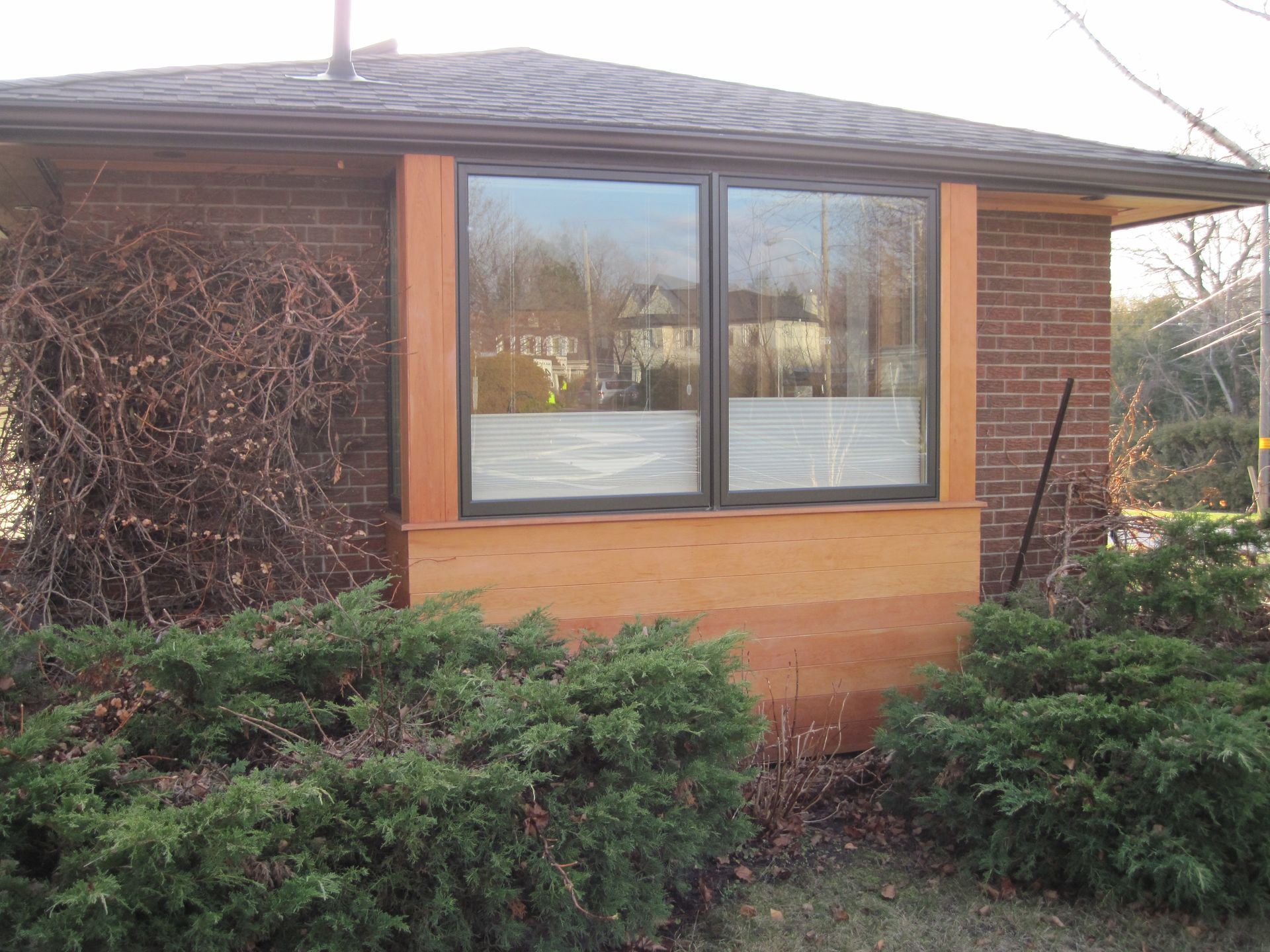 A brick house with a wooden trim around the windows