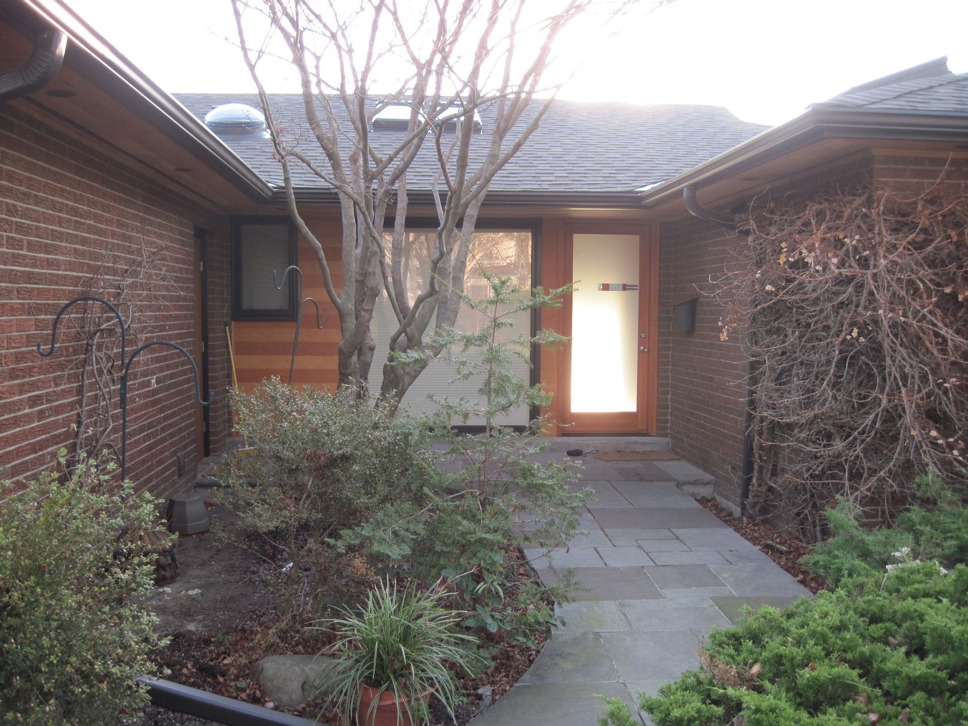 A brick house with a walkway leading to the front door