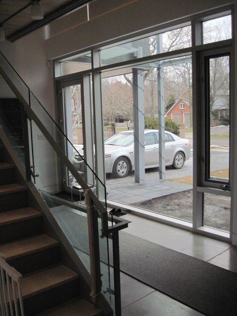 A white car is parked in front of a window with the number 115 on it