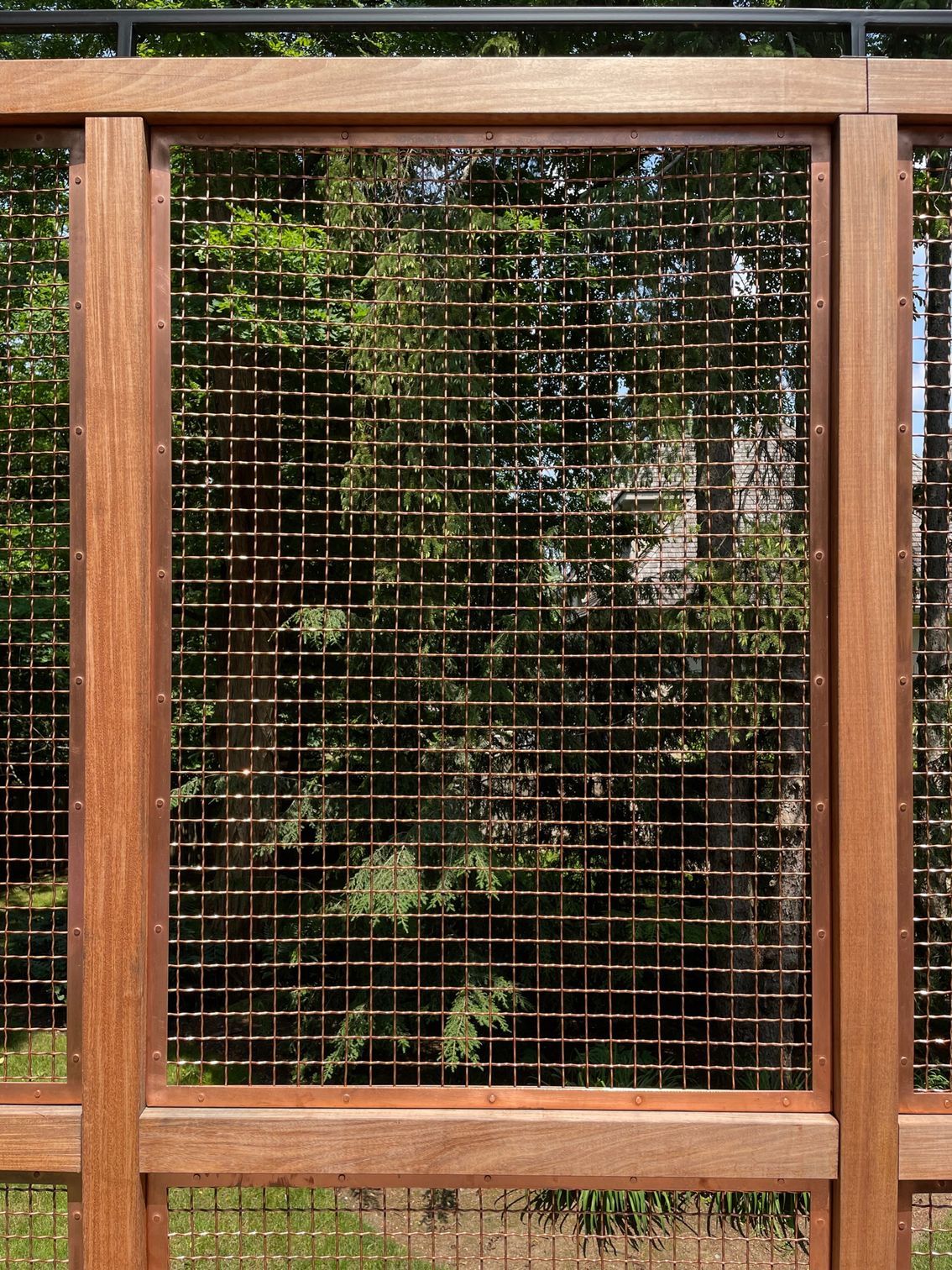 A wooden fence with a wire mesh behind it