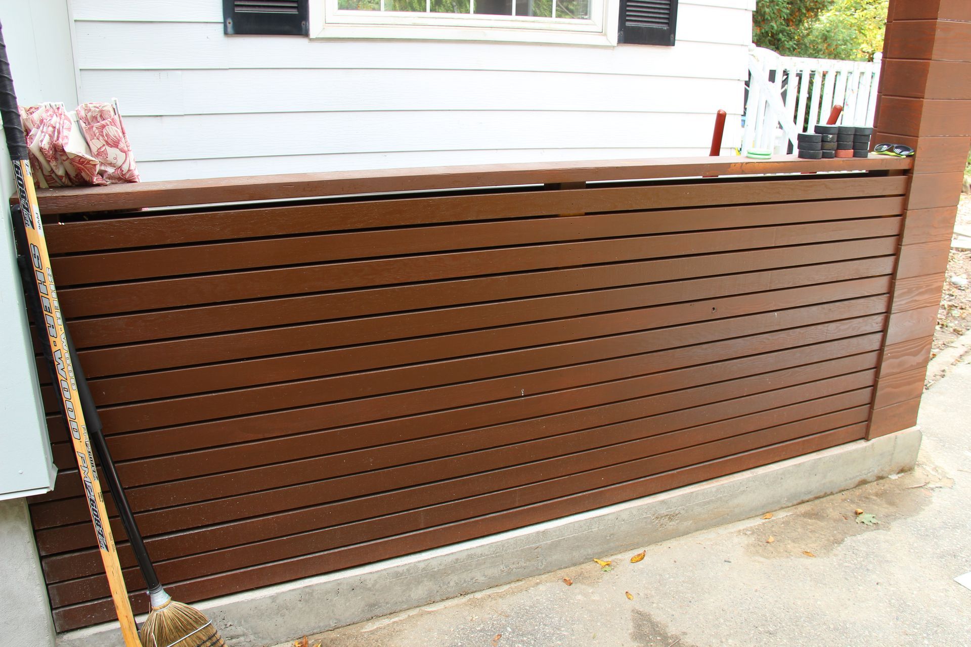 A wooden fence is sitting in front of a white house