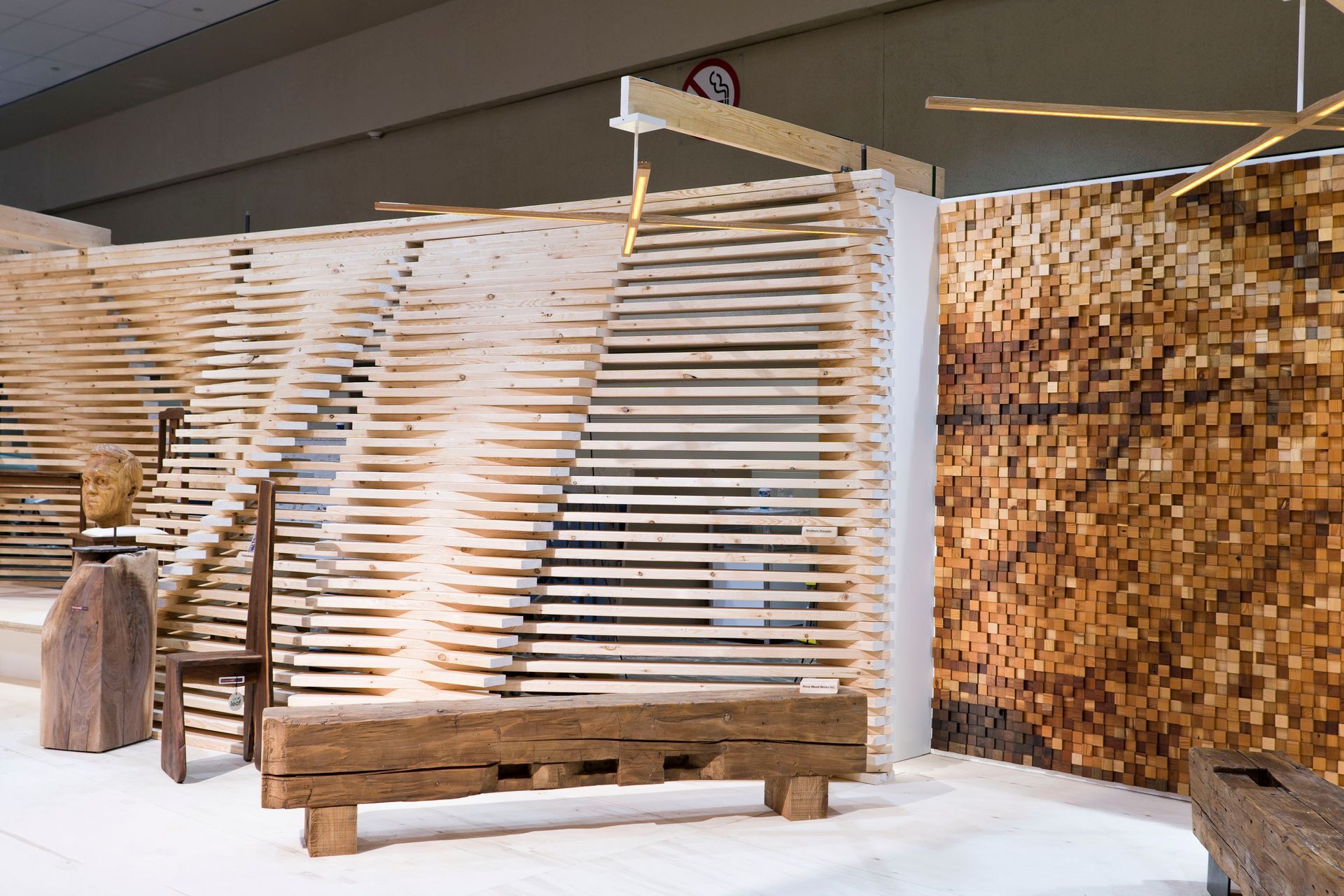 A wooden bench is sitting in front of a wooden wall.