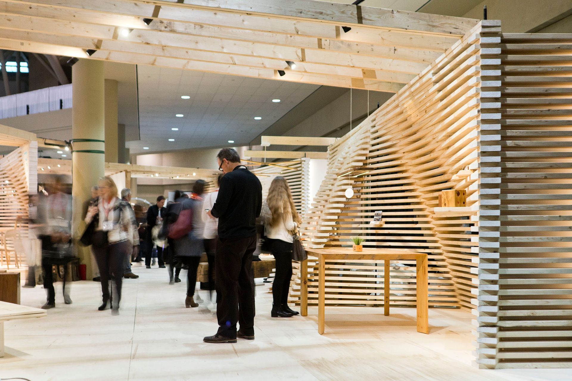 A group of people are standing in a room with wooden walls.