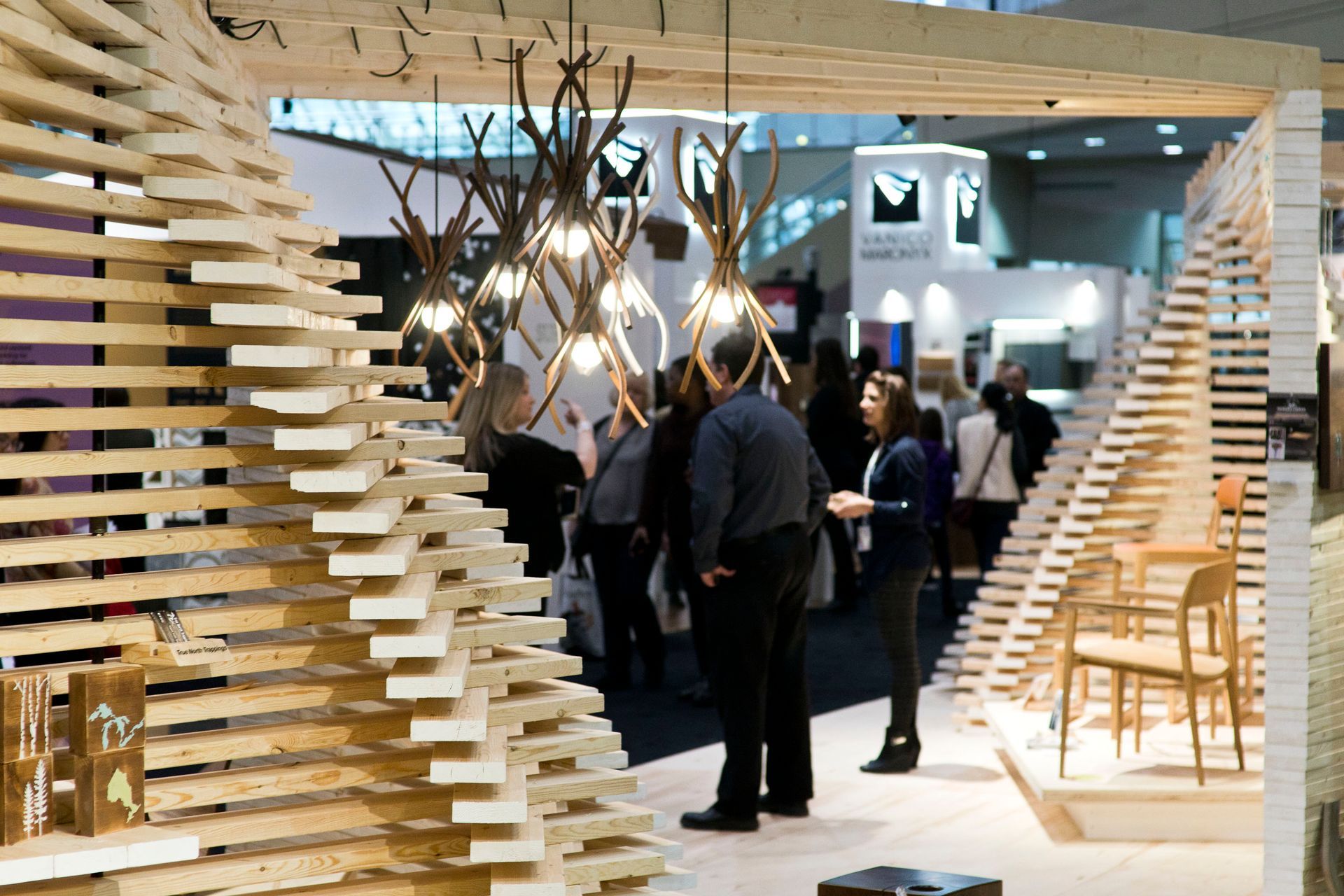 A group of people are standing in front of a wooden wall.