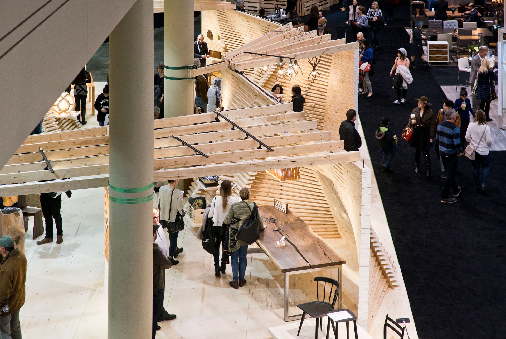 A group of people are standing in a room with tables and chairs