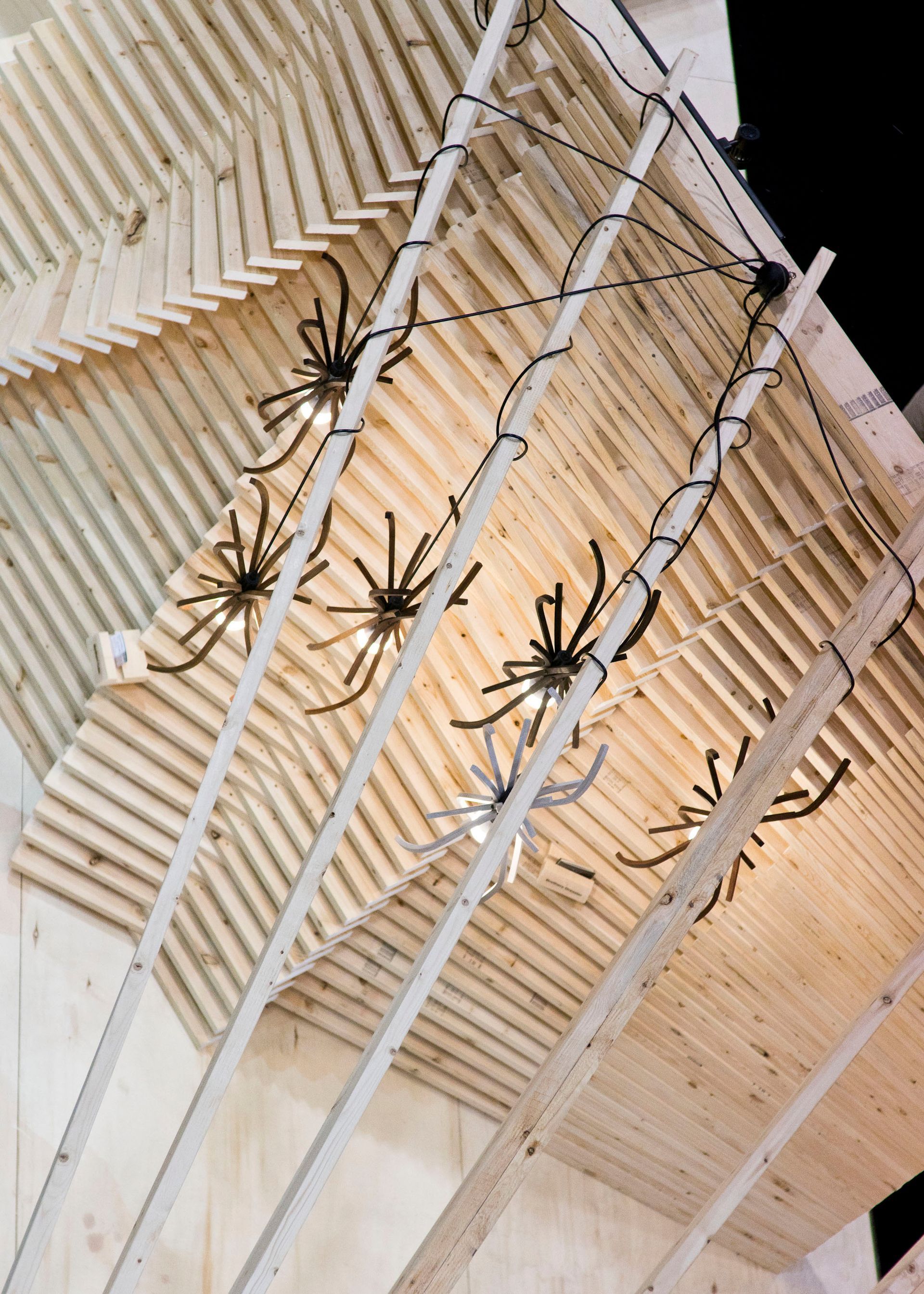 Spiders are hanging from the ceiling of a wooden structure
