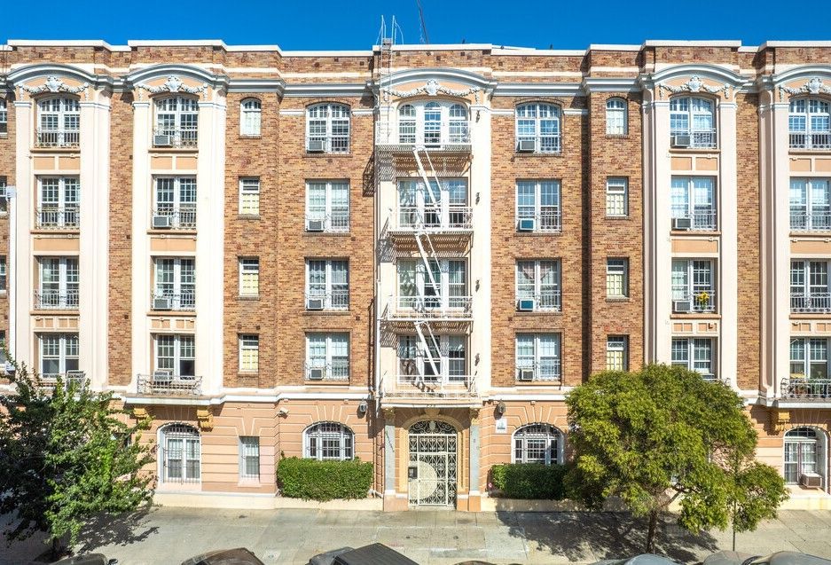 Multi-story brick apartment building with a central fire escape.