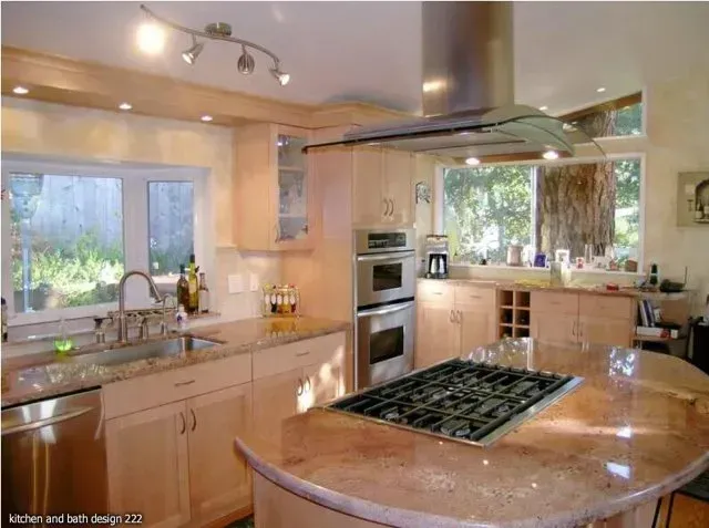 Kitchen with light wood cabinets, granite countertops, and a gas cooktop on an island.
