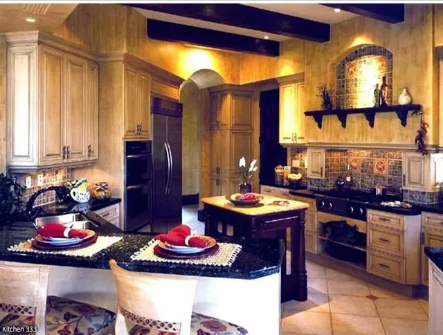 Kitchen with light wood cabinets, dark countertops, and a central island.