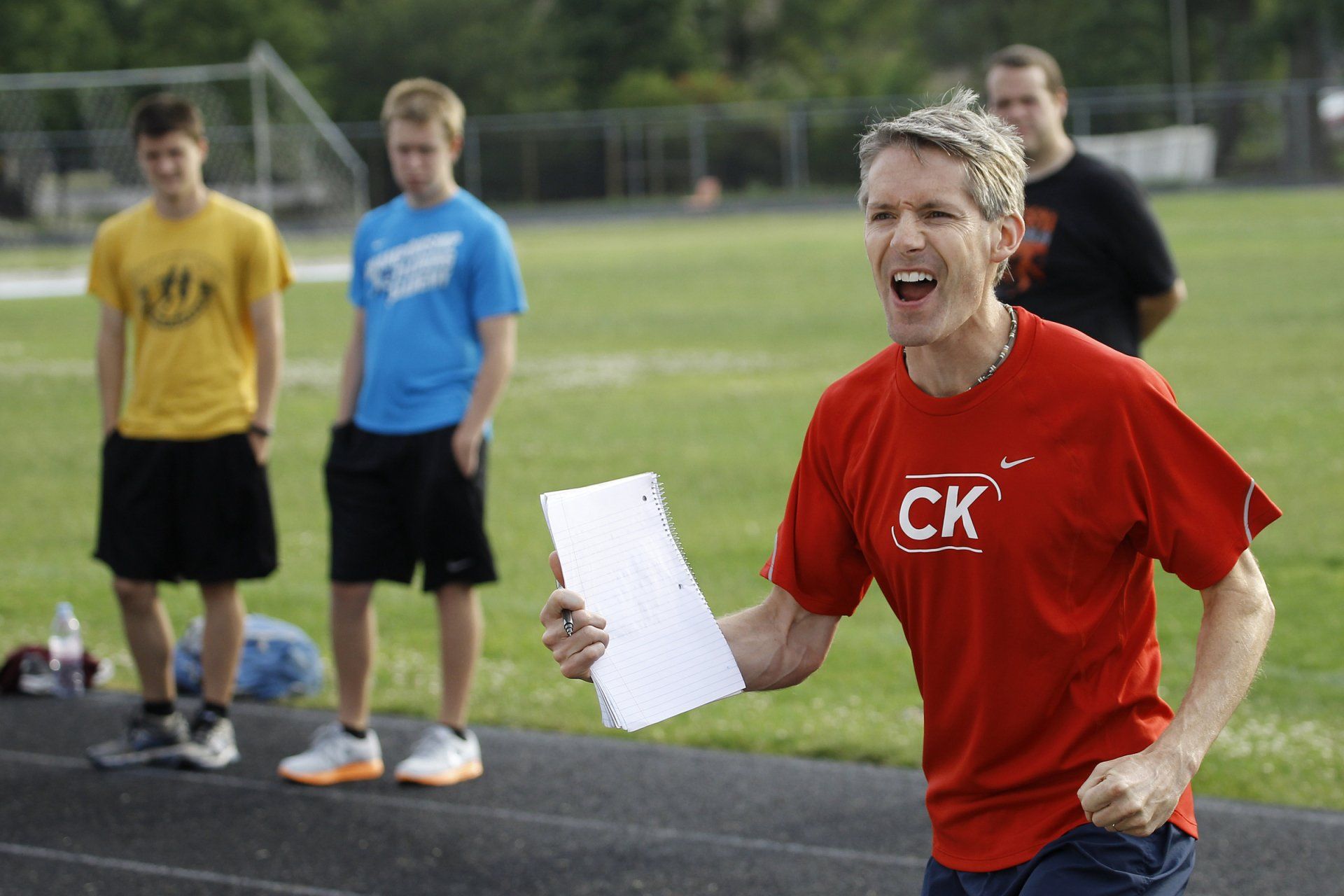 A man in a red ck shirt is holding a piece of paper