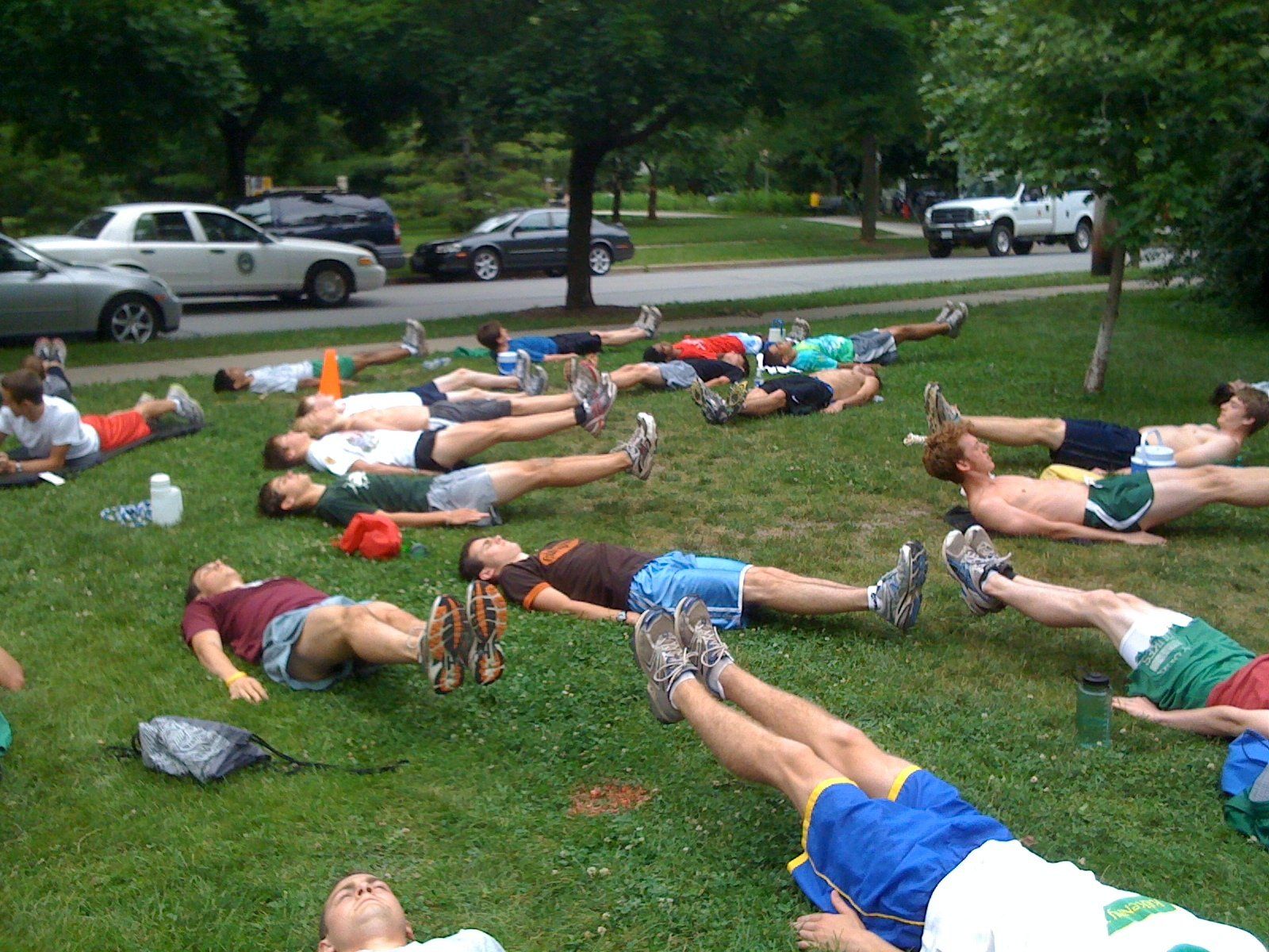 A group of people are laying on their backs in the grass