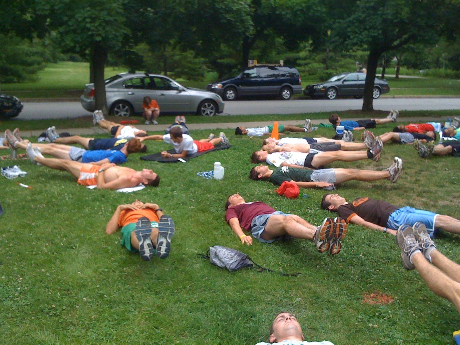 A group of people are laying on their stomachs in the grass
