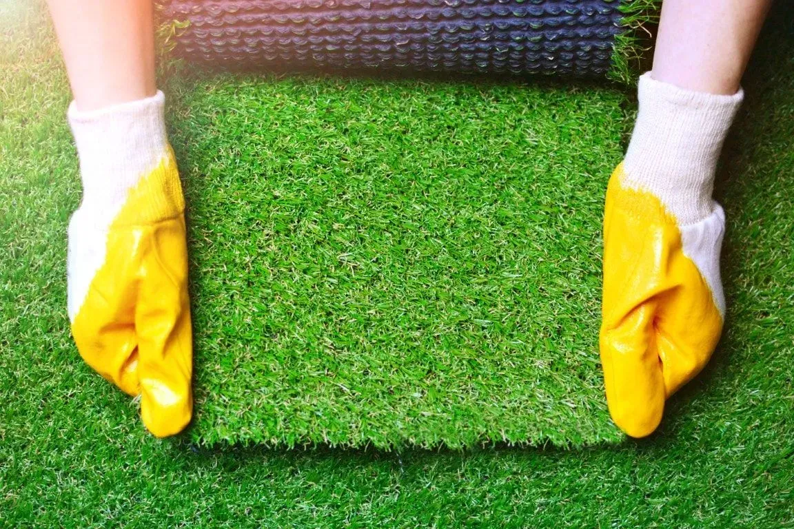 Laying a patch of artificial turf.