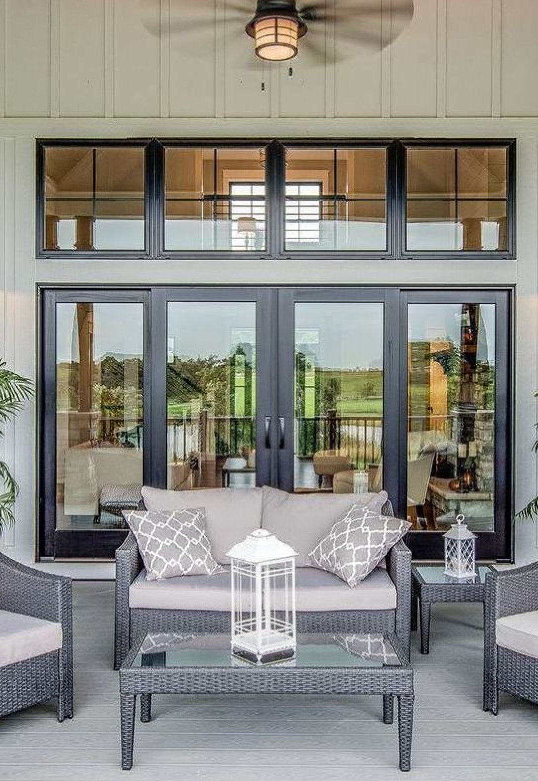 A woman is sitting at a desk with a laptop and a vase of flowers.
