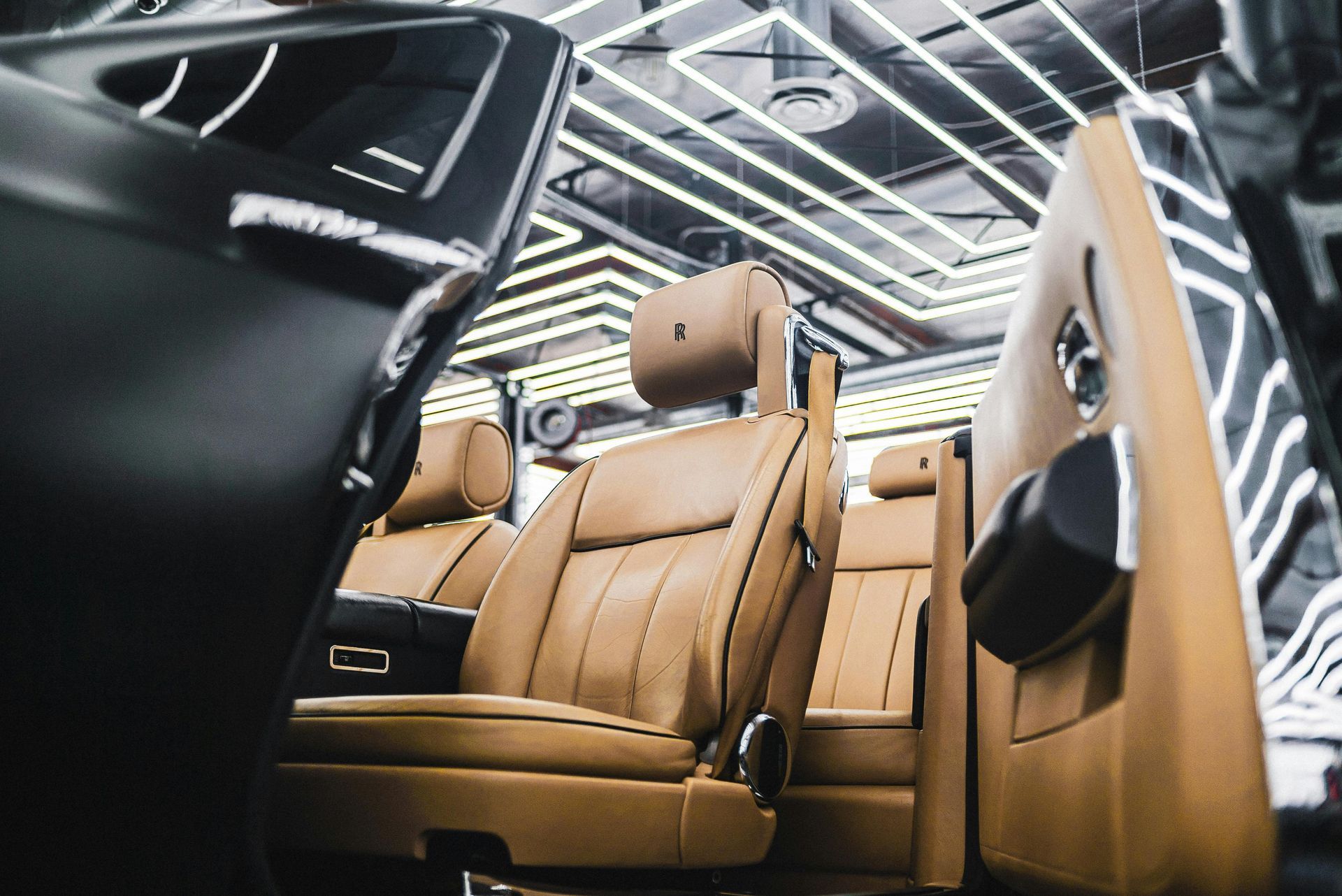 Tan leather car interior, black exterior, under bright lights.