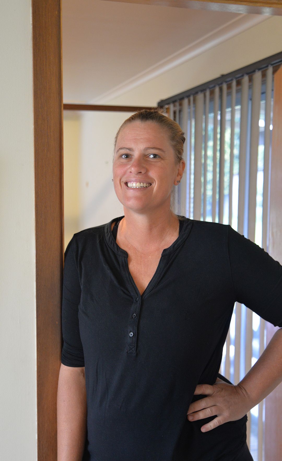 Headshot of smiling lady standing on angle looking straight on