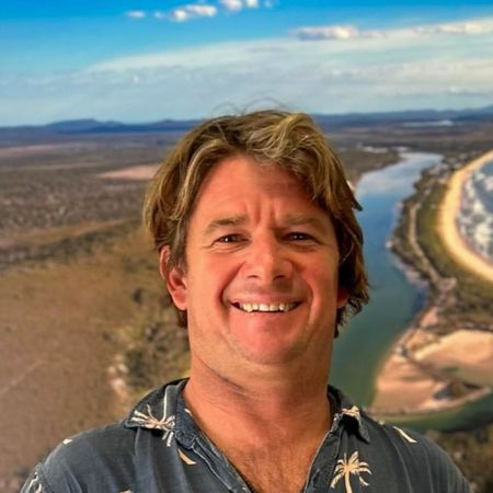 Bust image of smiling man standing in front of scene image