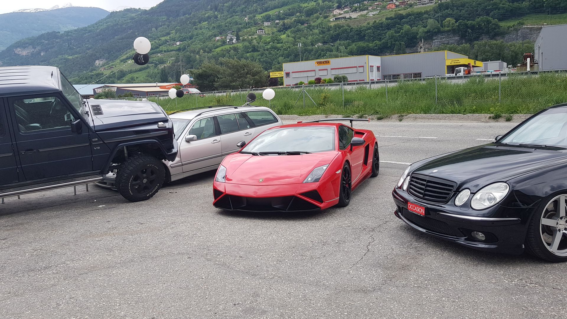 Un groupe de voitures sont garées les unes à côté des autres dans un parking.