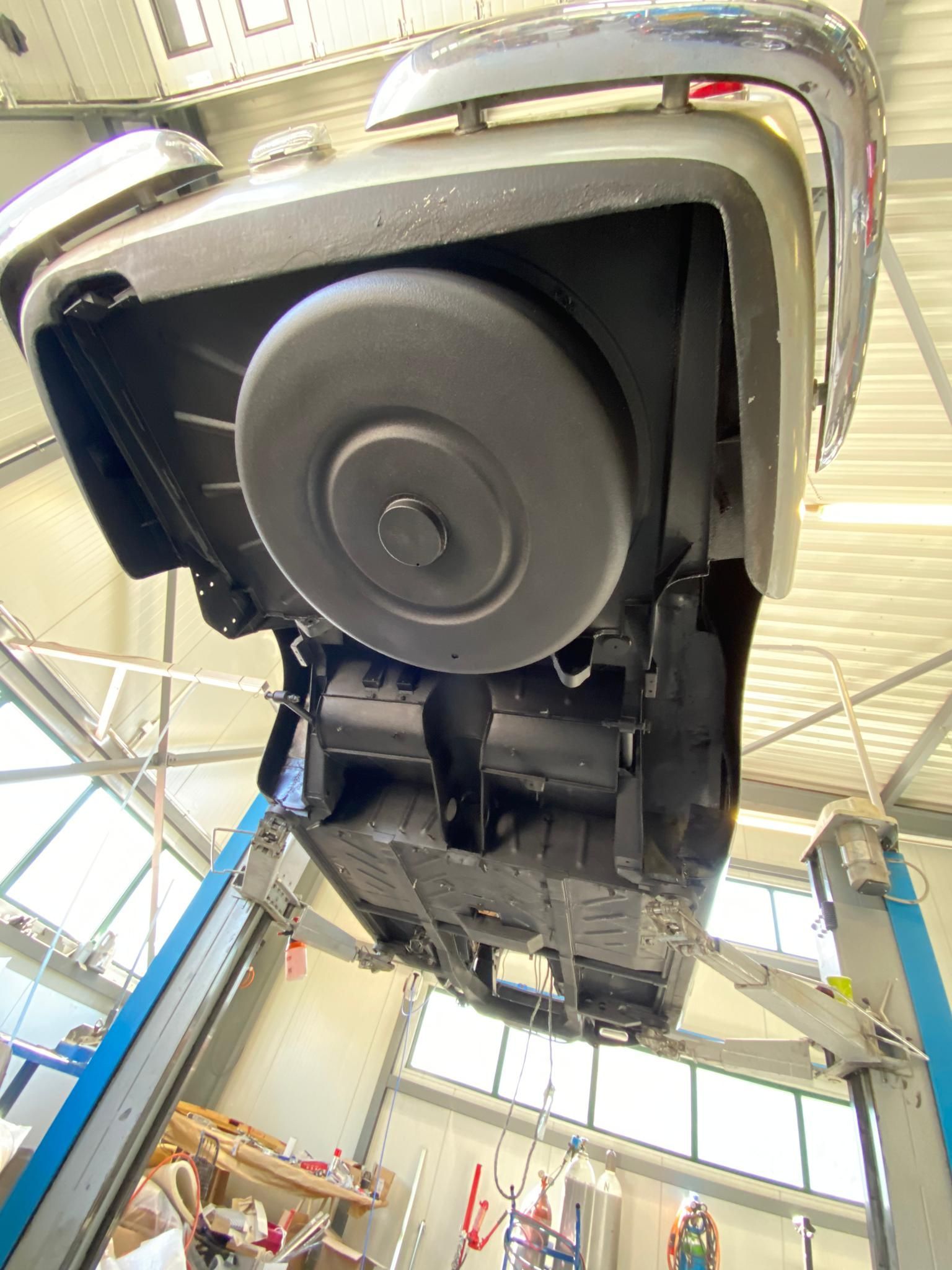 Une voiture est posée sur un ascenseur dans un garage.