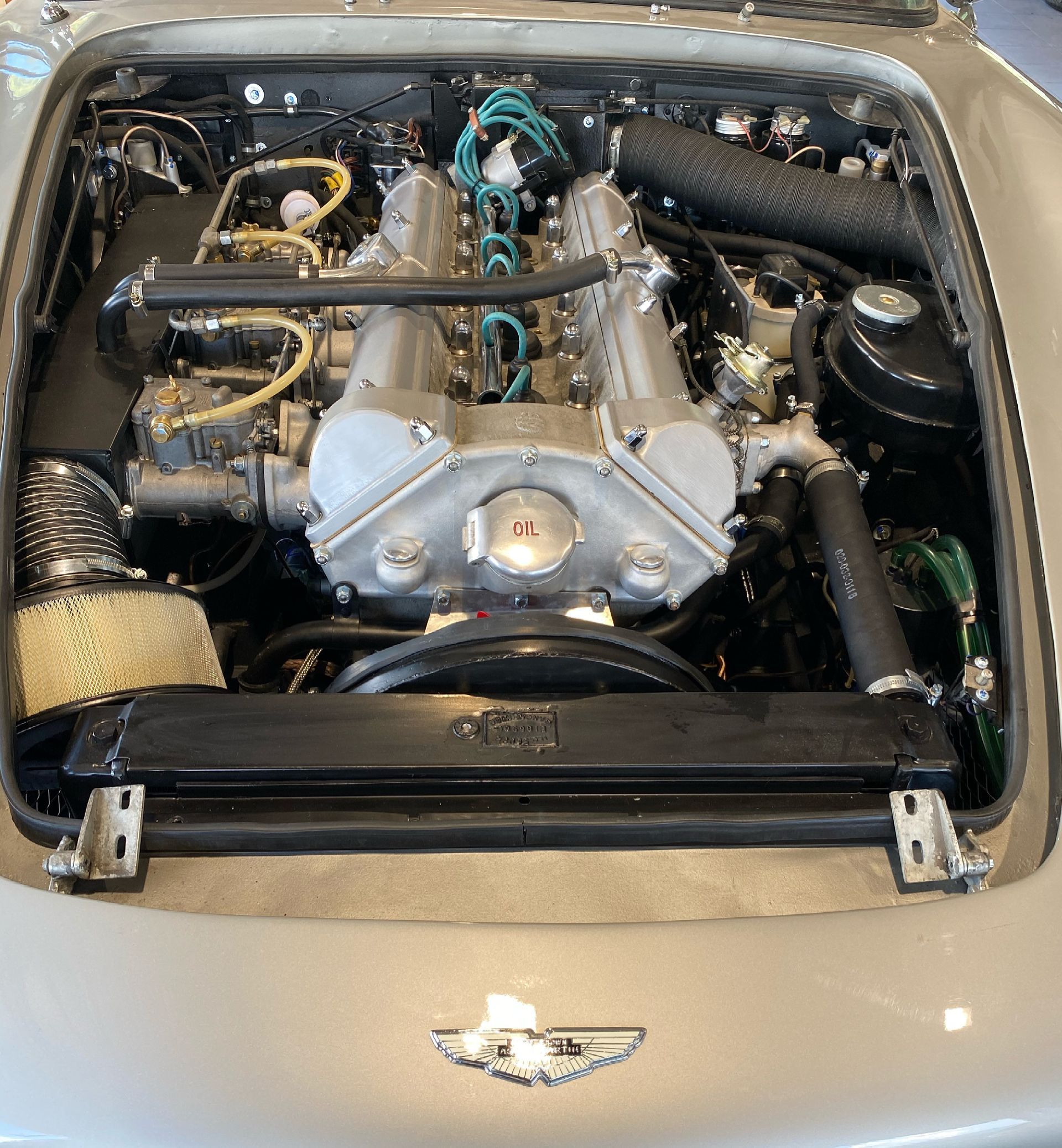 Un gros plan d'un moteur de voiture avec le capot ouvert.