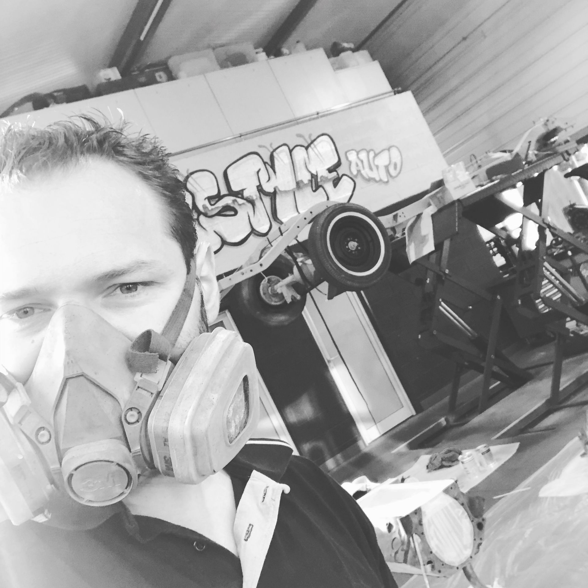 Un homme portant un masque à gaz devant un panneau indiquant style