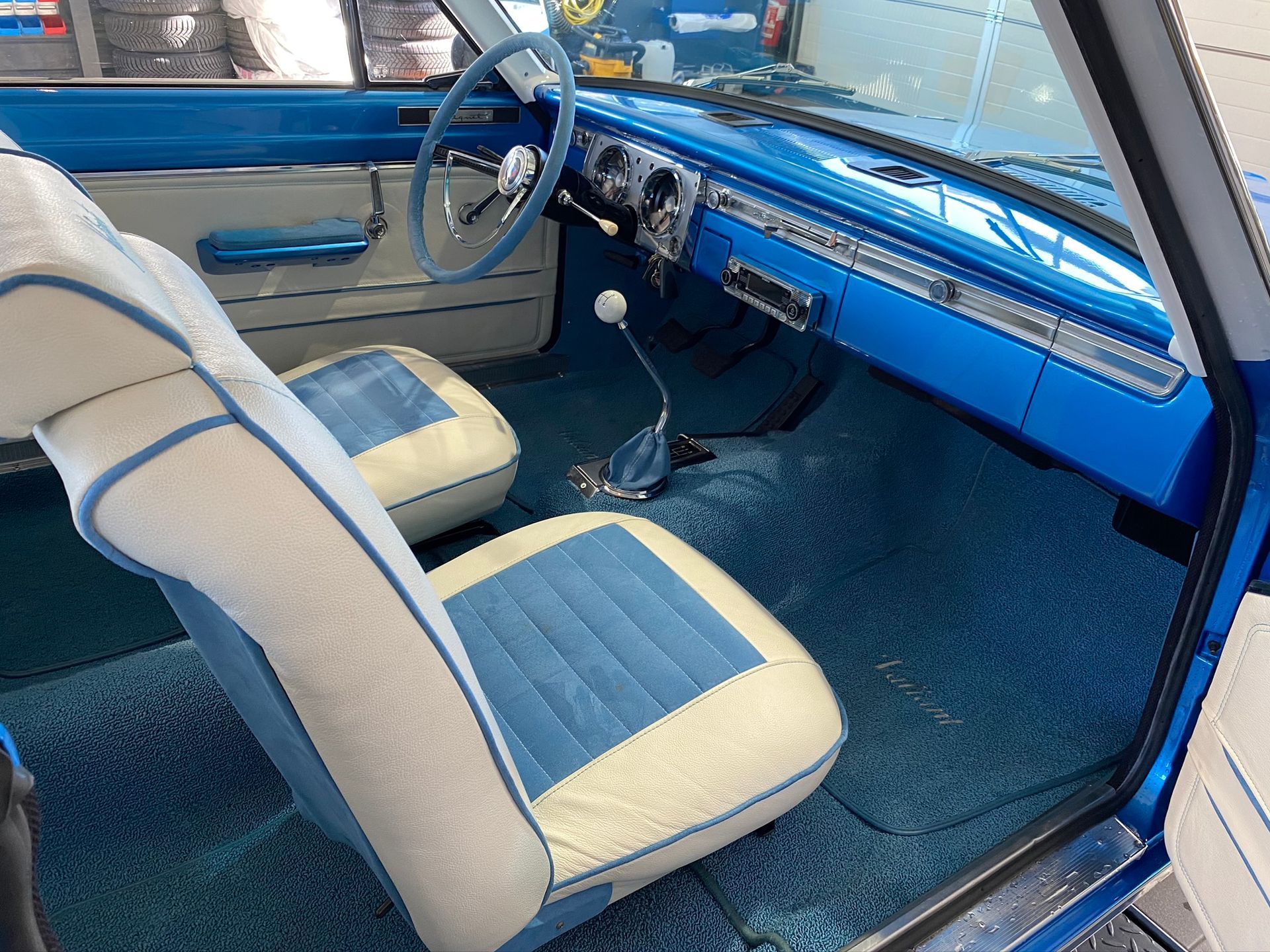 L'intérieur d'une voiture bleue avec des sièges bleus et blancs