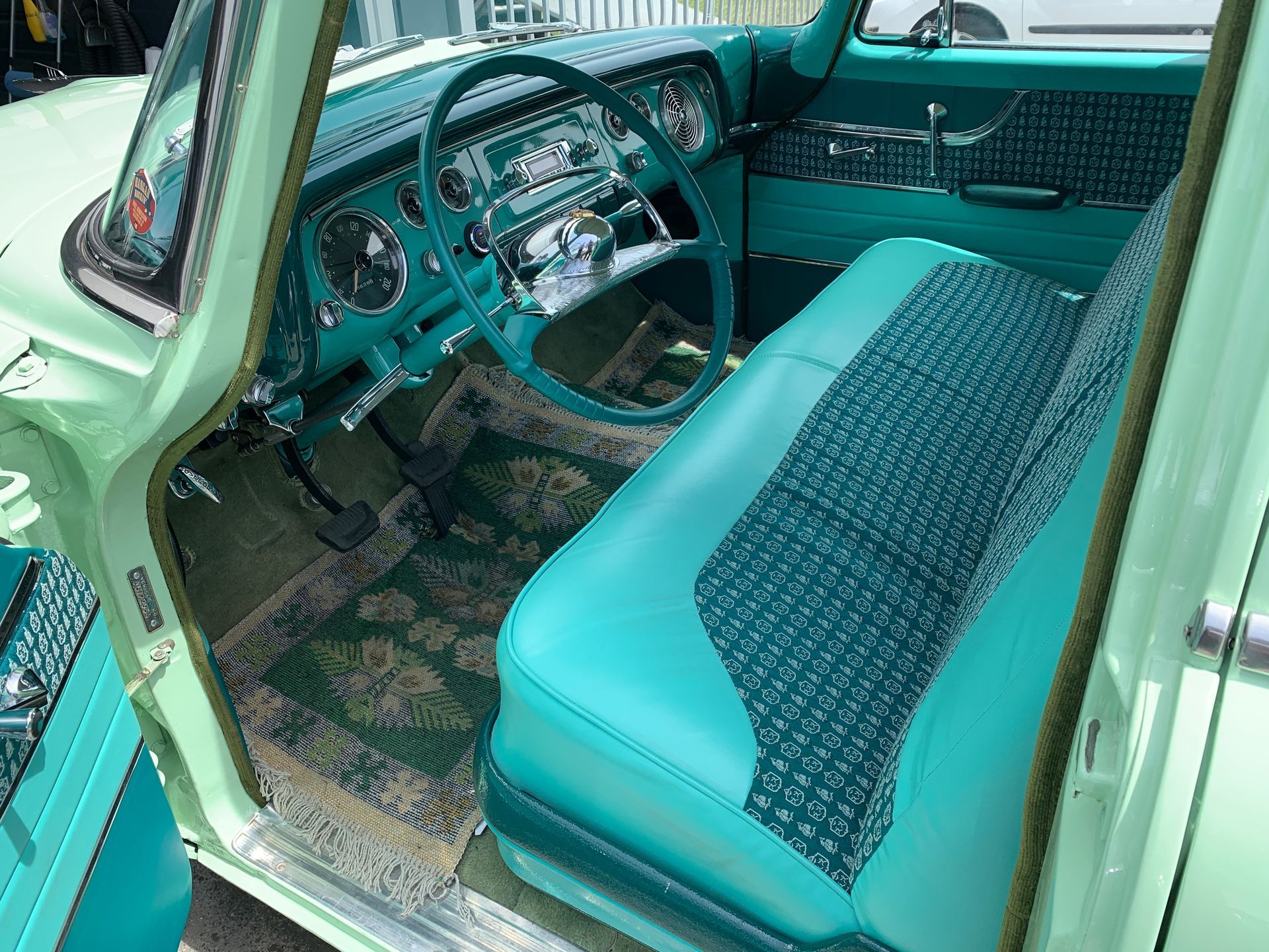 L'intérieur d'une voiture verte avec des sièges bleus et un volant.