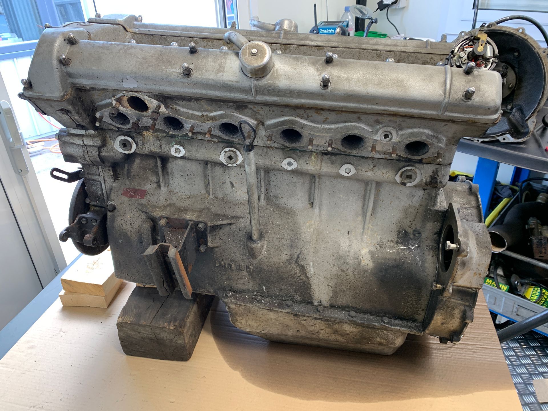 Un vieux moteur est posé sur une table en bois.