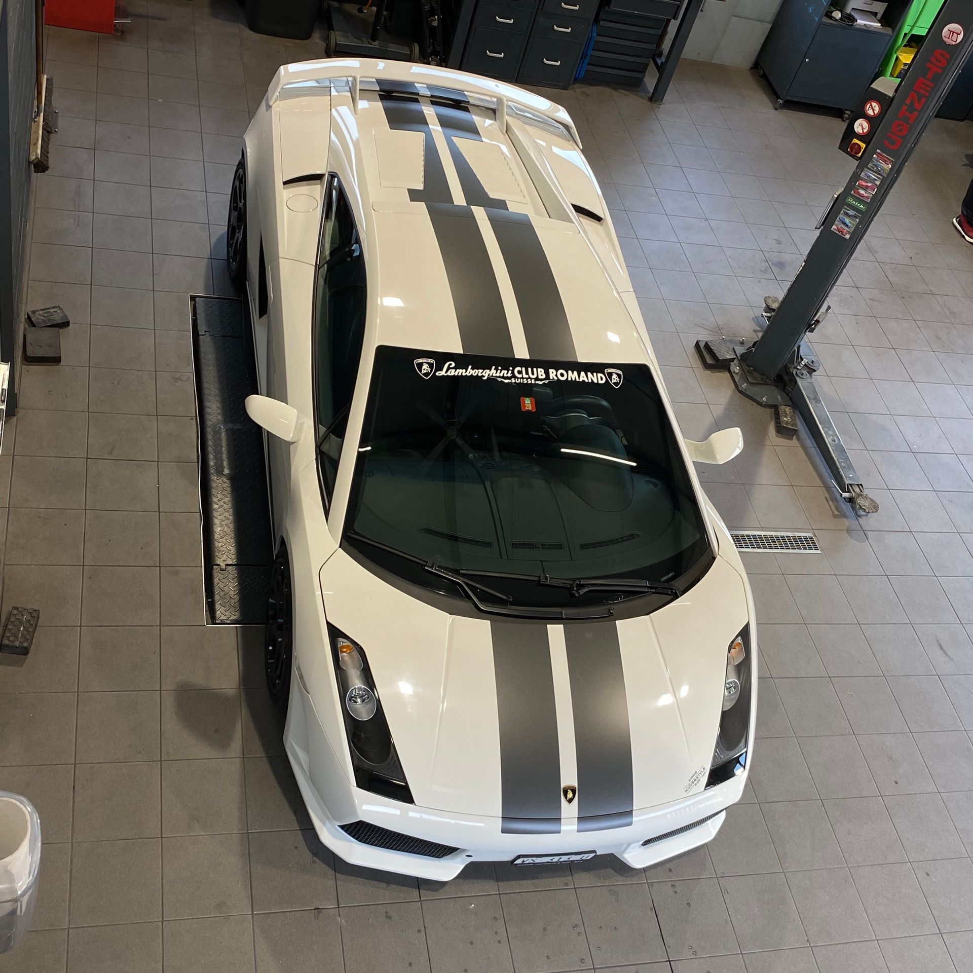 Une voiture blanche avec des rayures noires est garée dans un garage