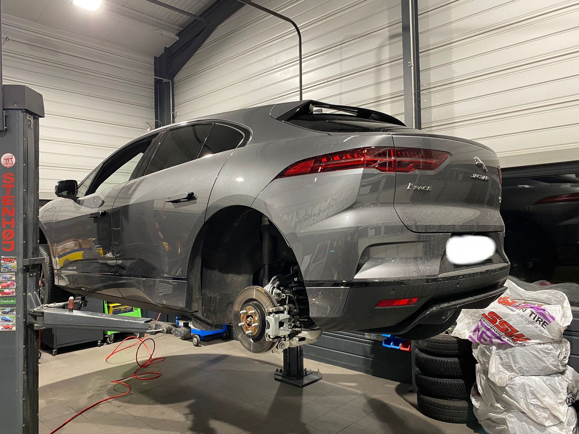 Un Jaguar I Pace est assis sur un ascenseur dans un garage.