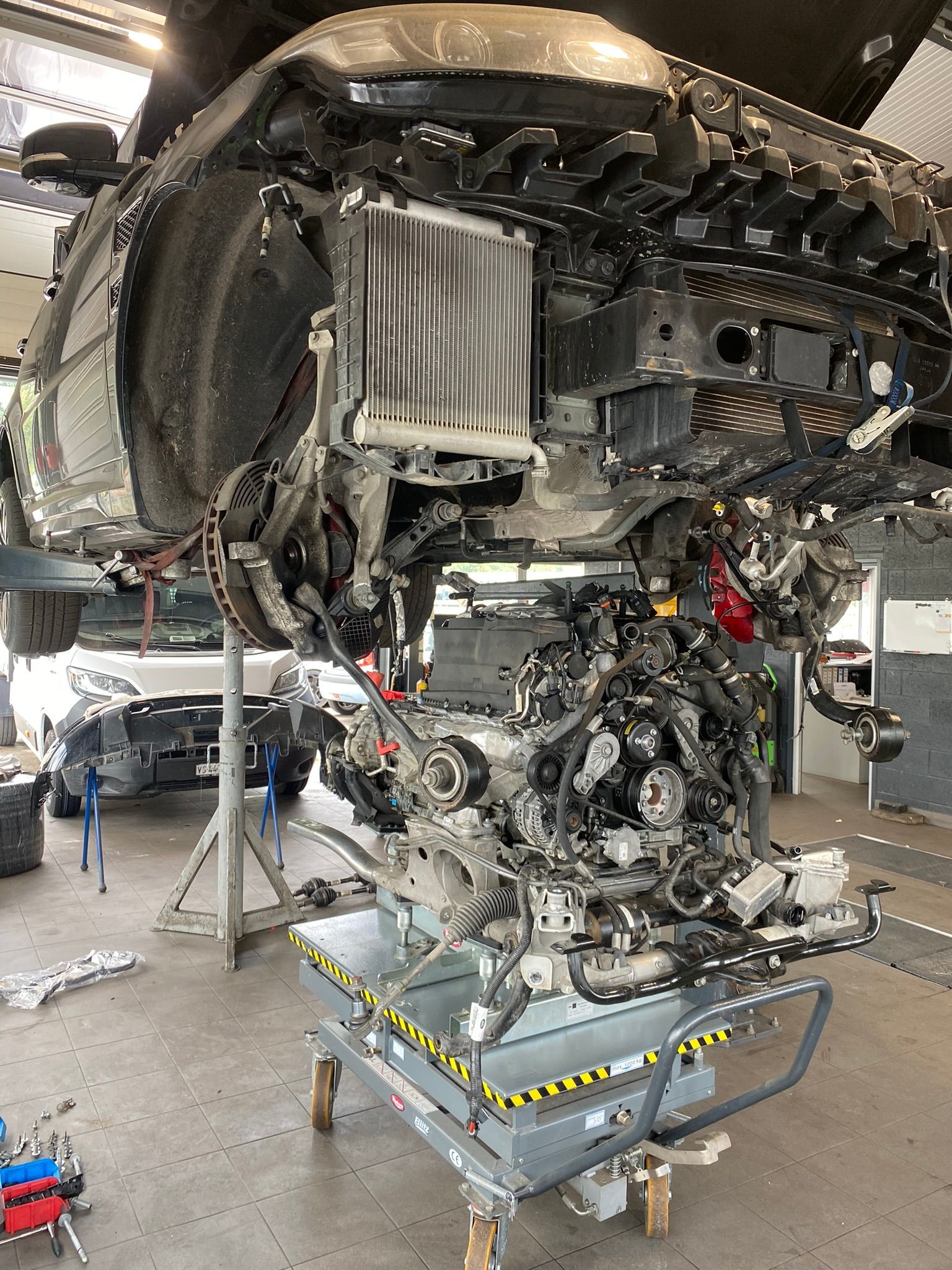 Le moteur d'une voiture est déposé dans un garage.