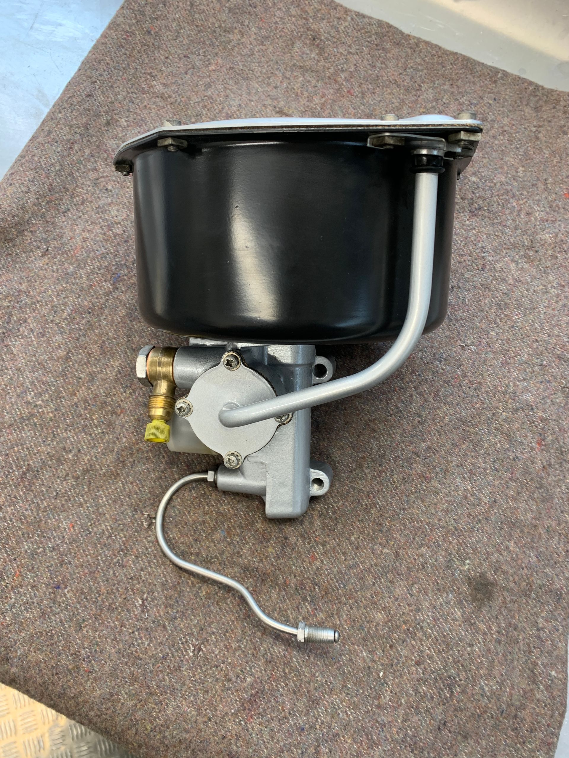 Un bol noir auquel est fixé un tuyau est posé sur un tapis.