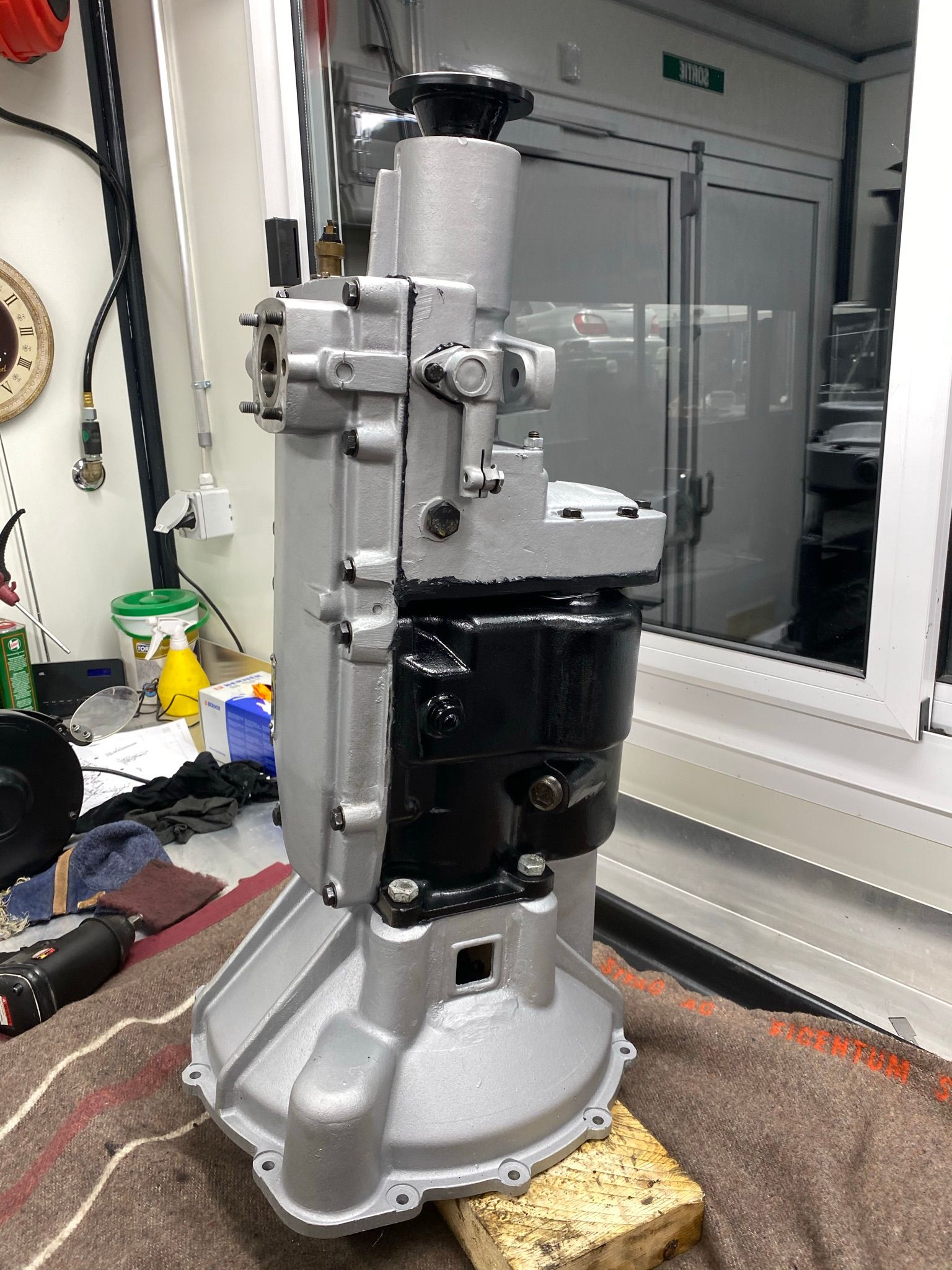 Une boîte de vitesses est posée sur un bloc de bois sur une table.