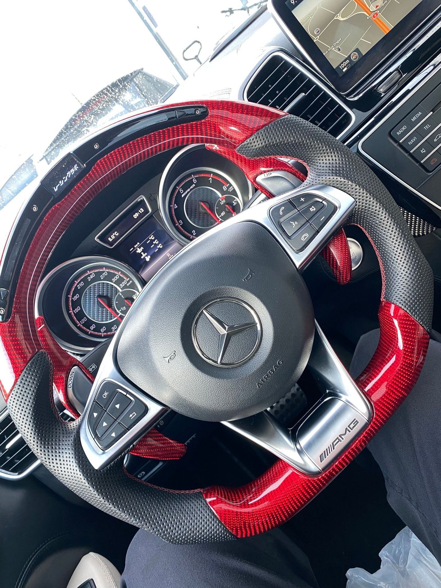 Un gros plan d'un volant rouge et noir dans une voiture.