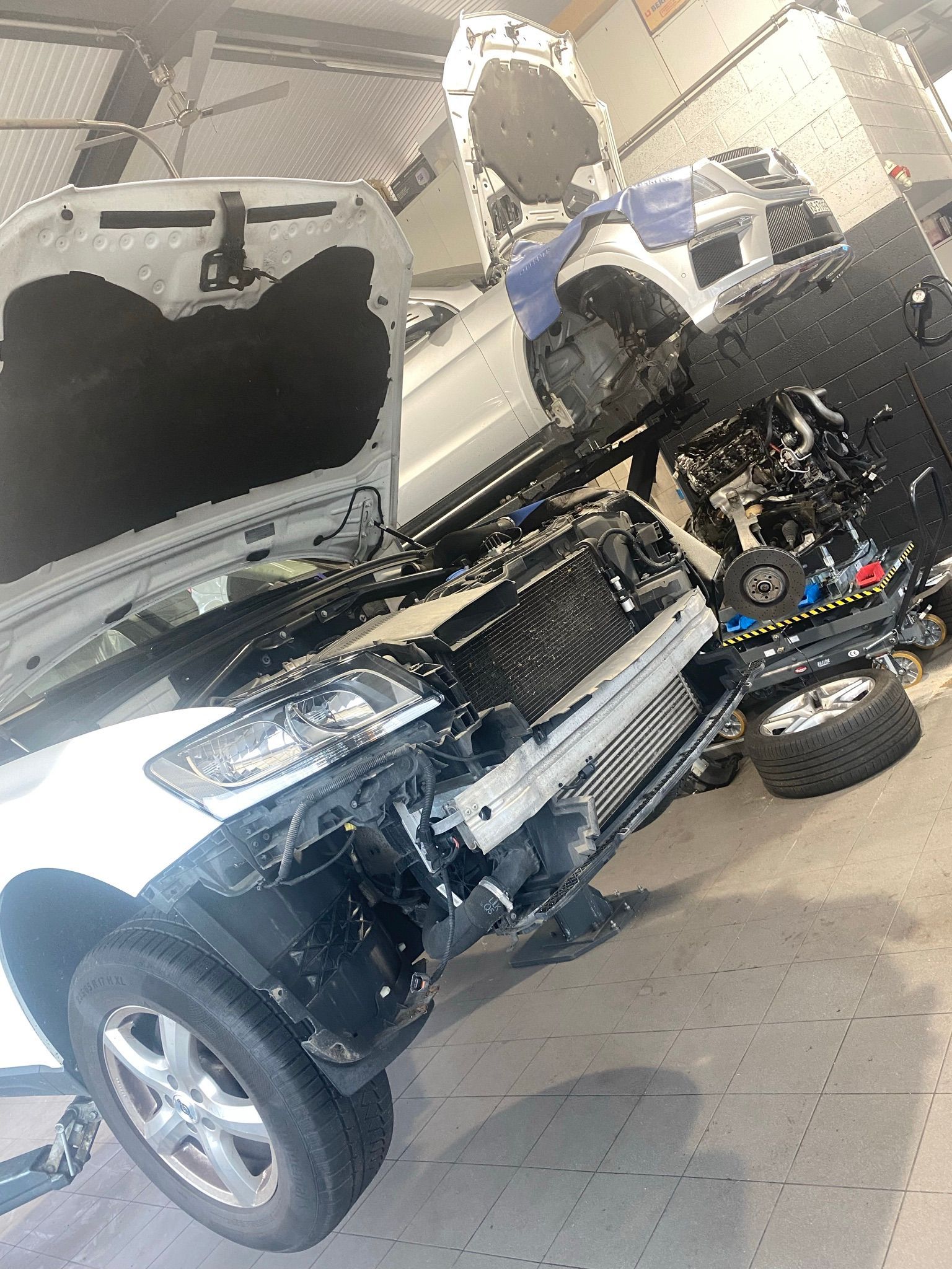 Un camion blanc est en train d'être démonté dans un garage.