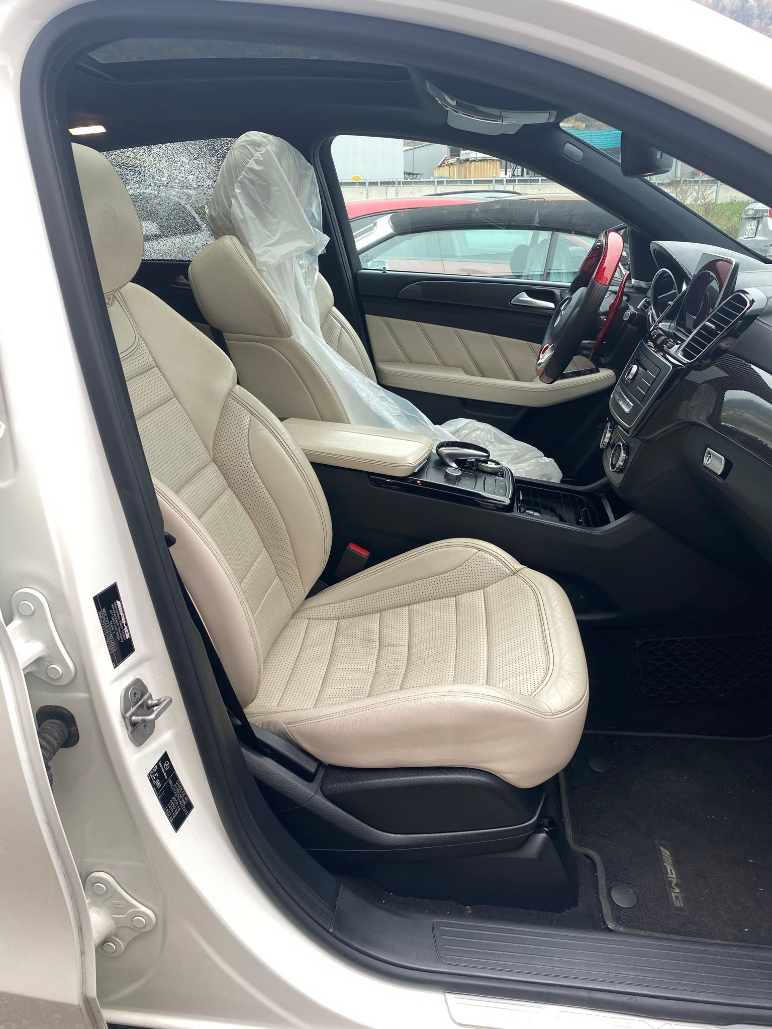 L’intérieur d’une voiture blanche avec la porte ouverte et les sièges enveloppés de plastique.