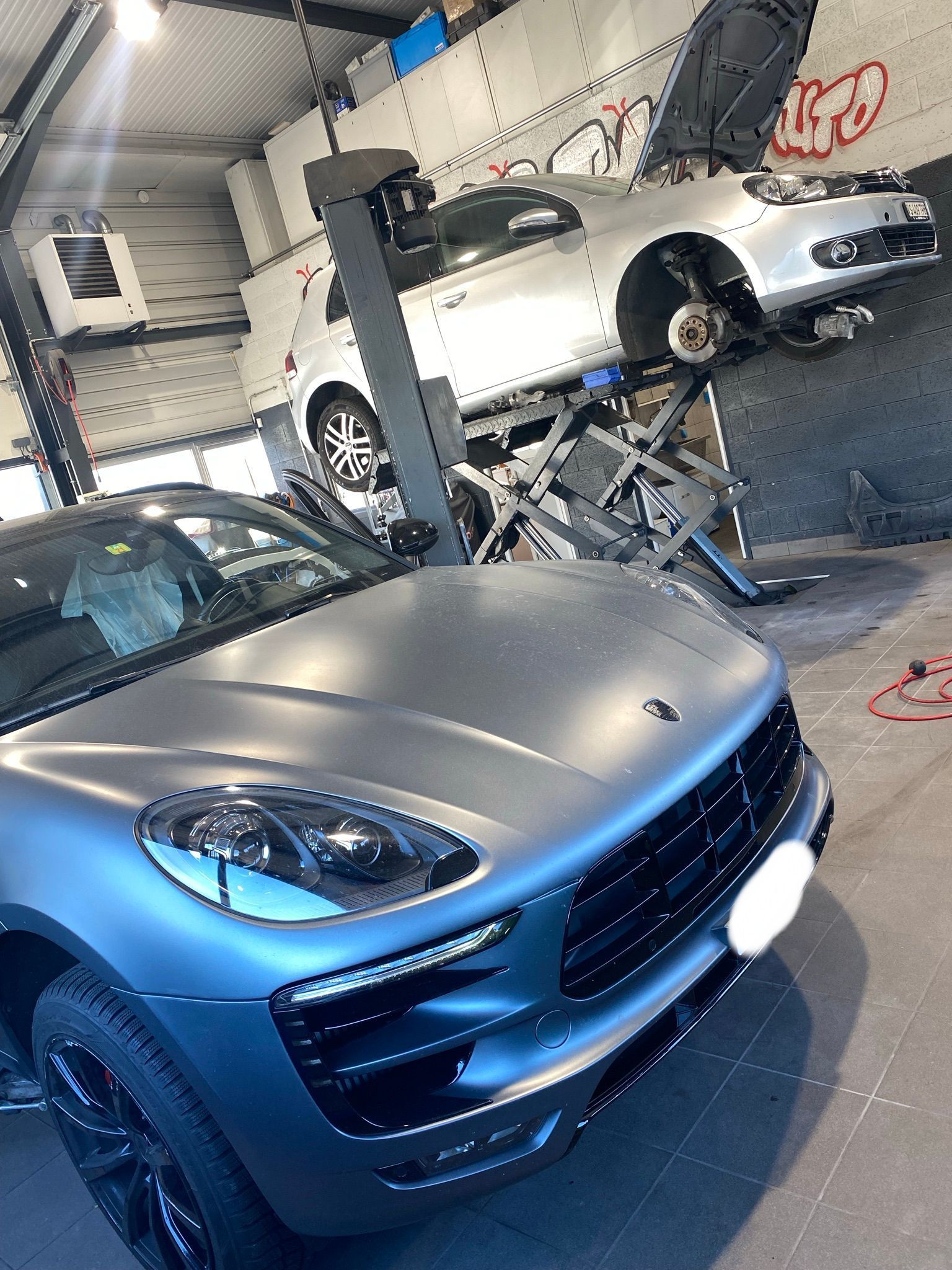 Une Porsche Macan Turbo est garée dans un garage.