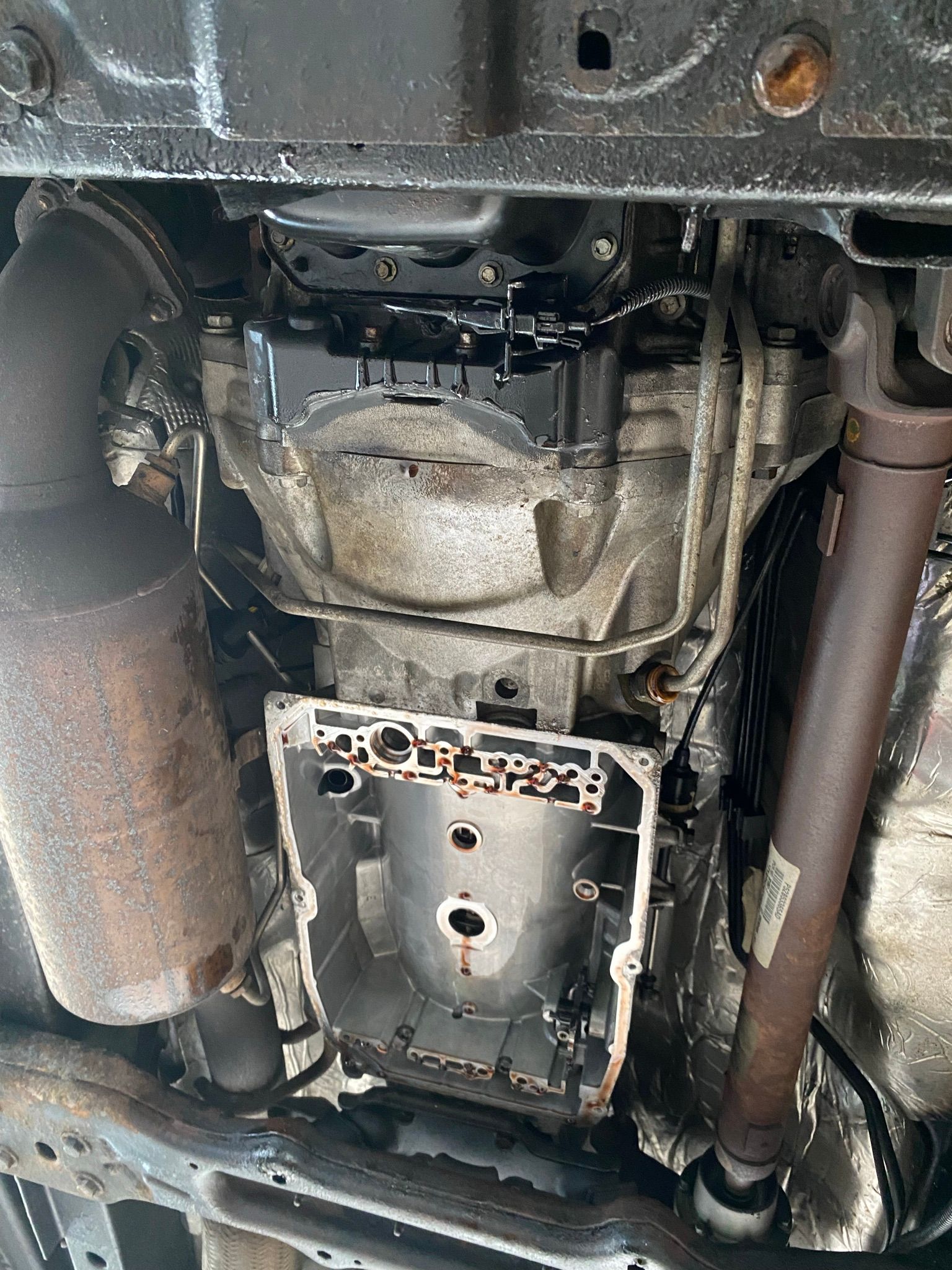 Un gros plan du dessous d’une voiture avec le moteur déposé.