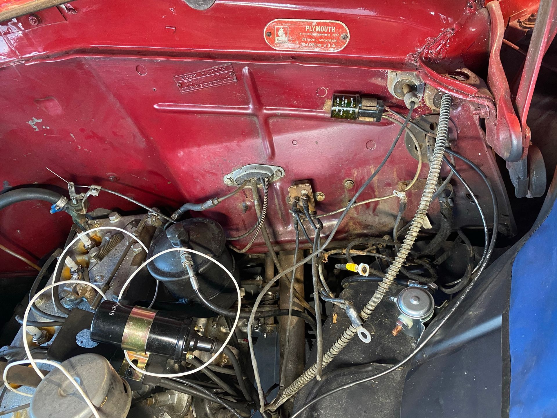 Un gros plan d'un moteur de voiture rouge avec beaucoup de fils qui en sortent.