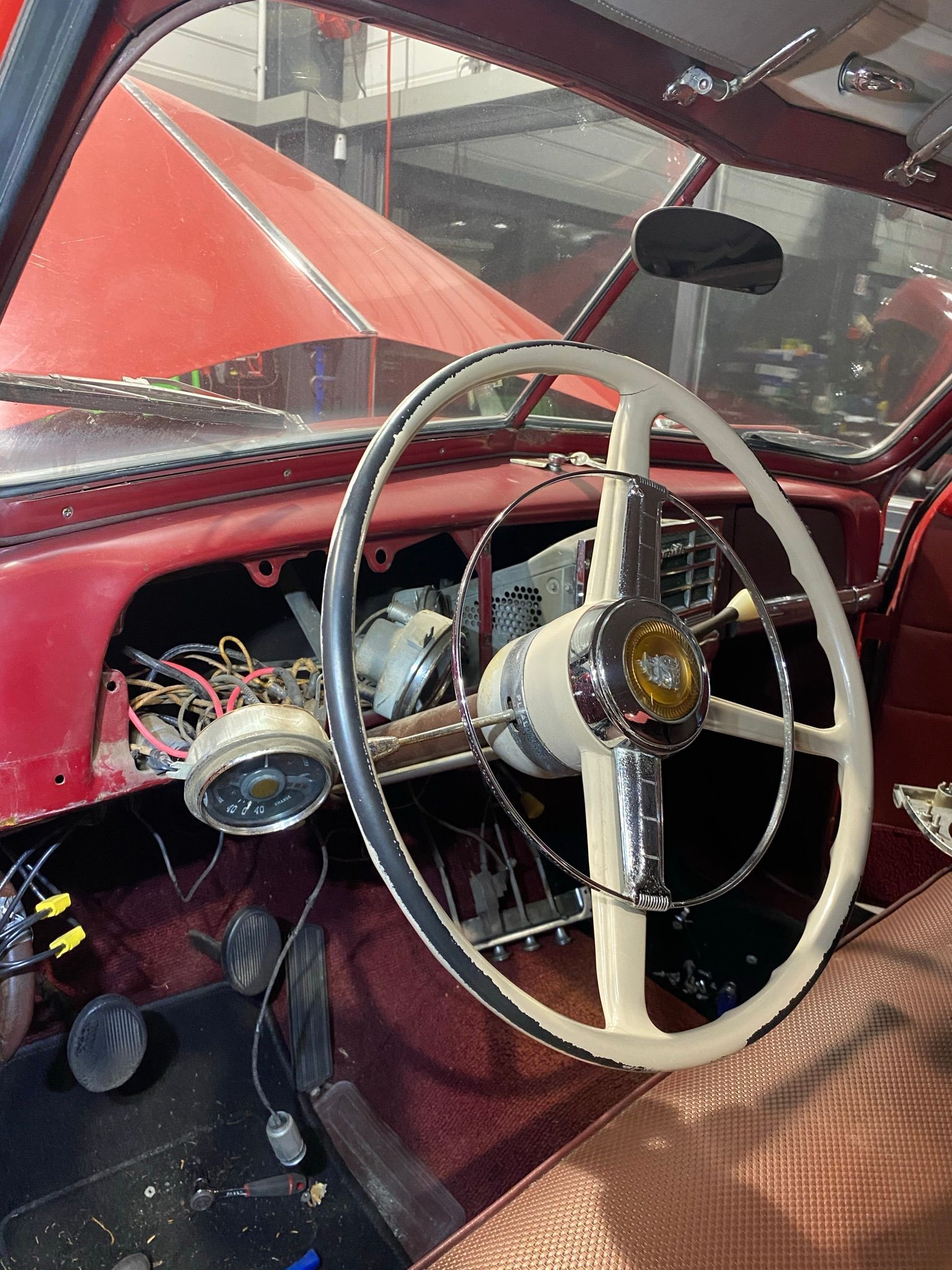 L'intérieur d'une voiture rouge avec un volant blanc