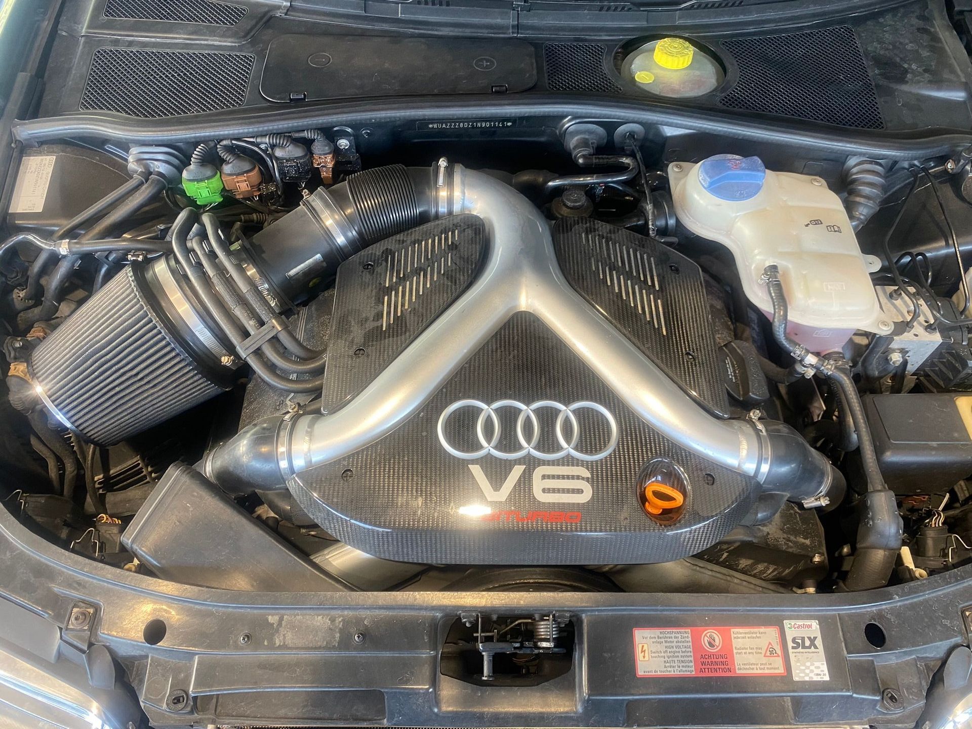 Le moteur d’une Audi V6 est représenté avec le capot ouvert.