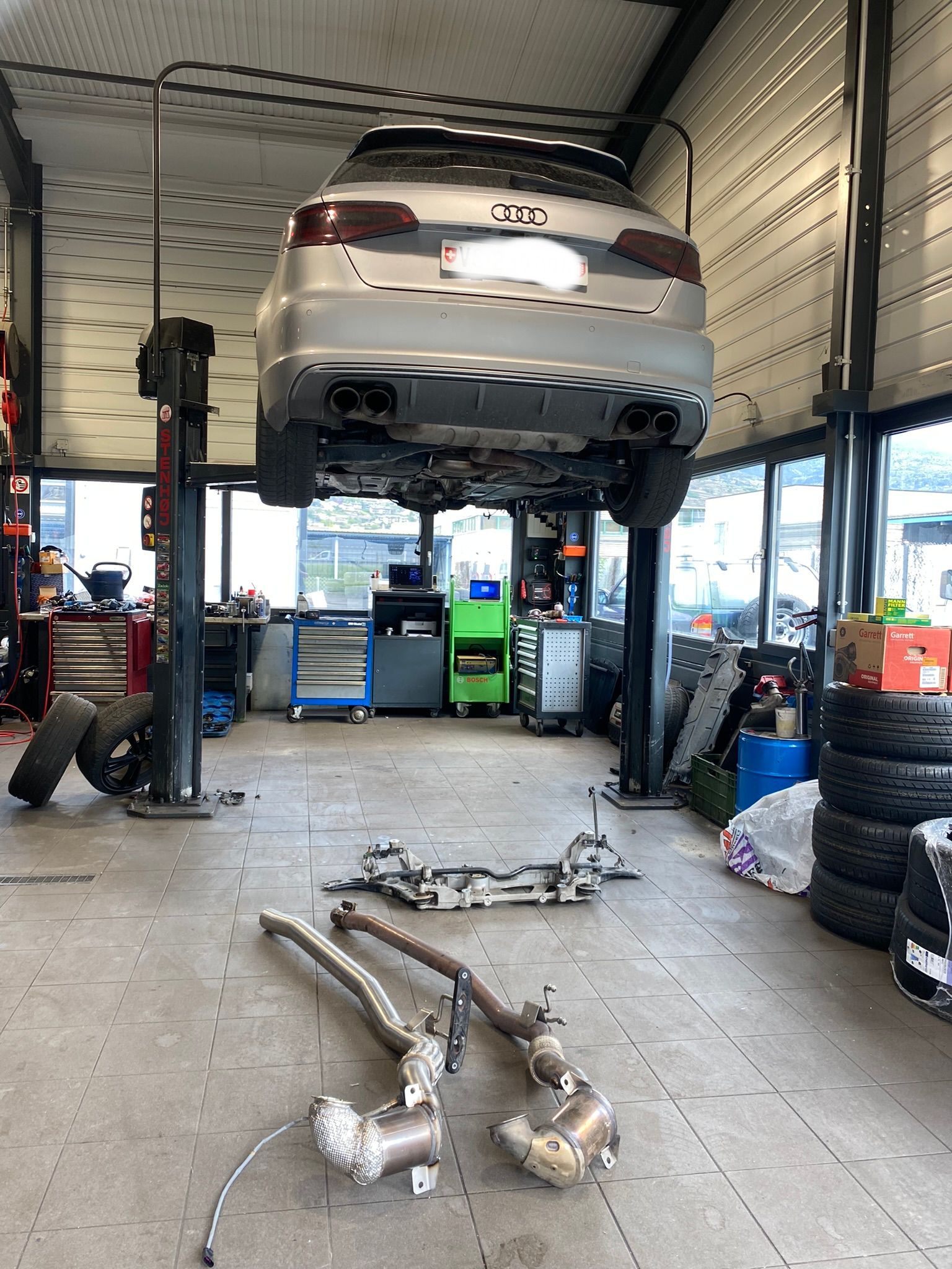 Une voiture est posée sur un ascenseur dans un garage.