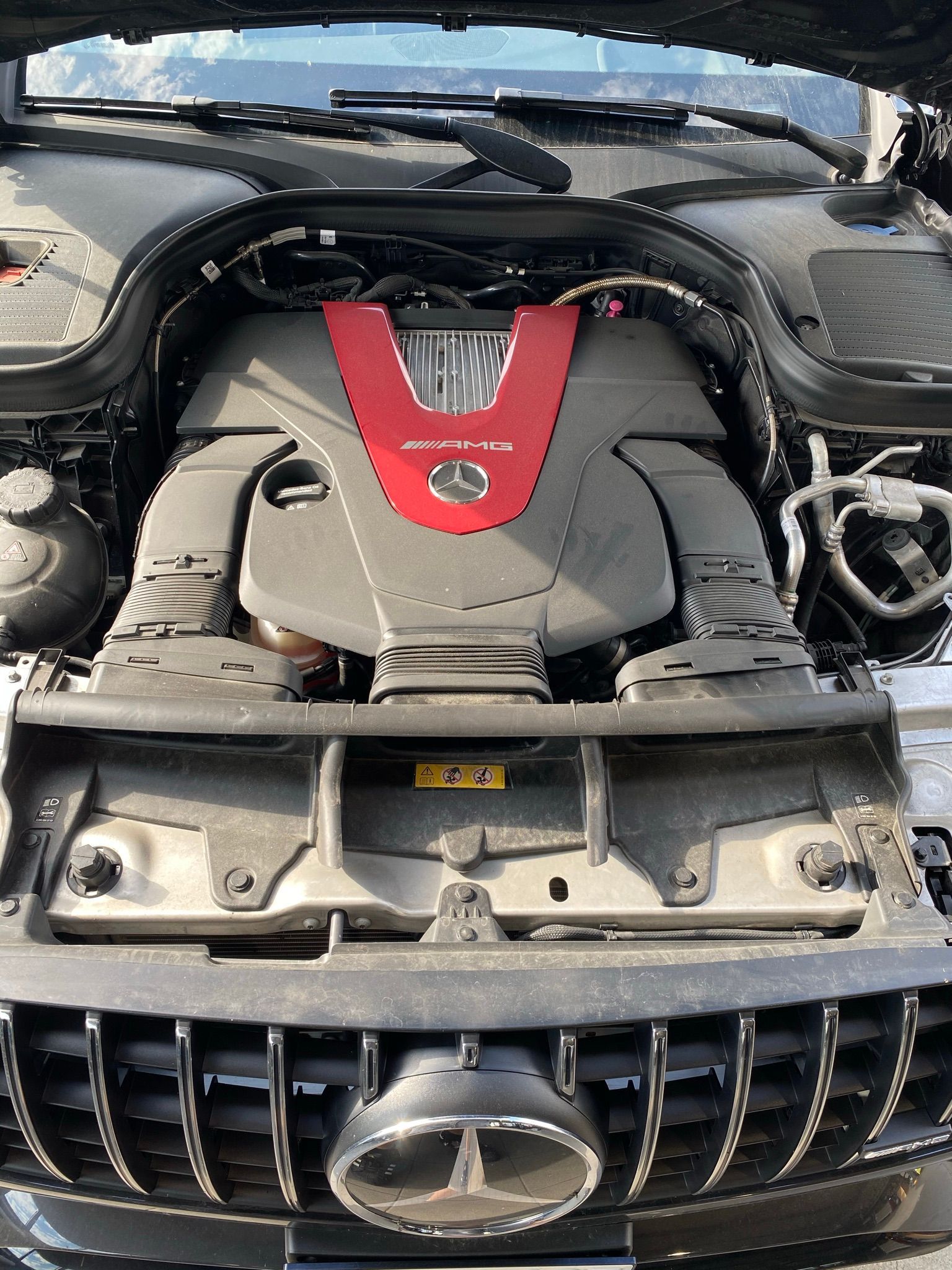 Le moteur d’une Mercedes Benz est représenté avec le capot ouvert.