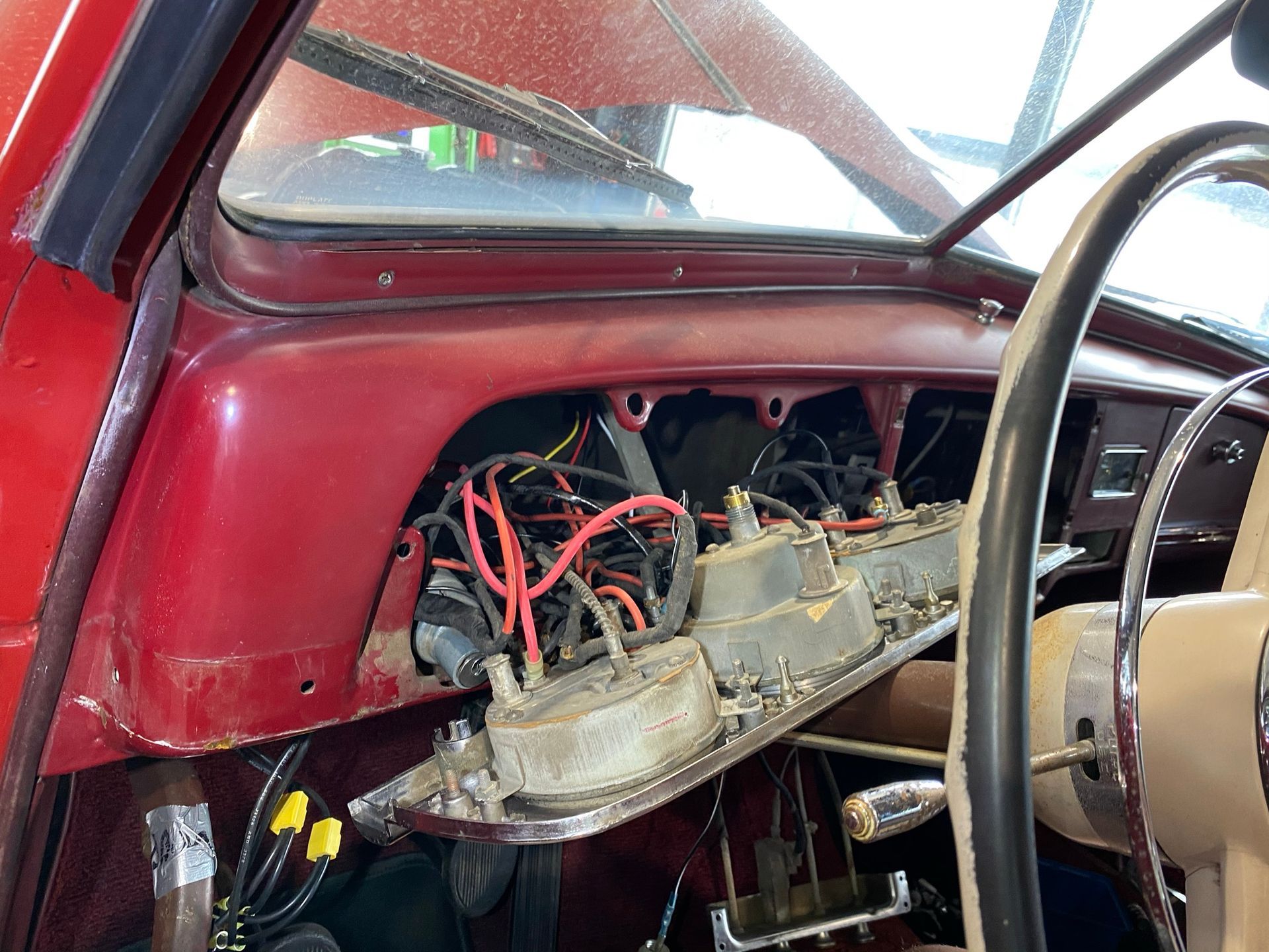 Le tableau de bord d’une voiture rouge avec beaucoup de fils qui en sortent.