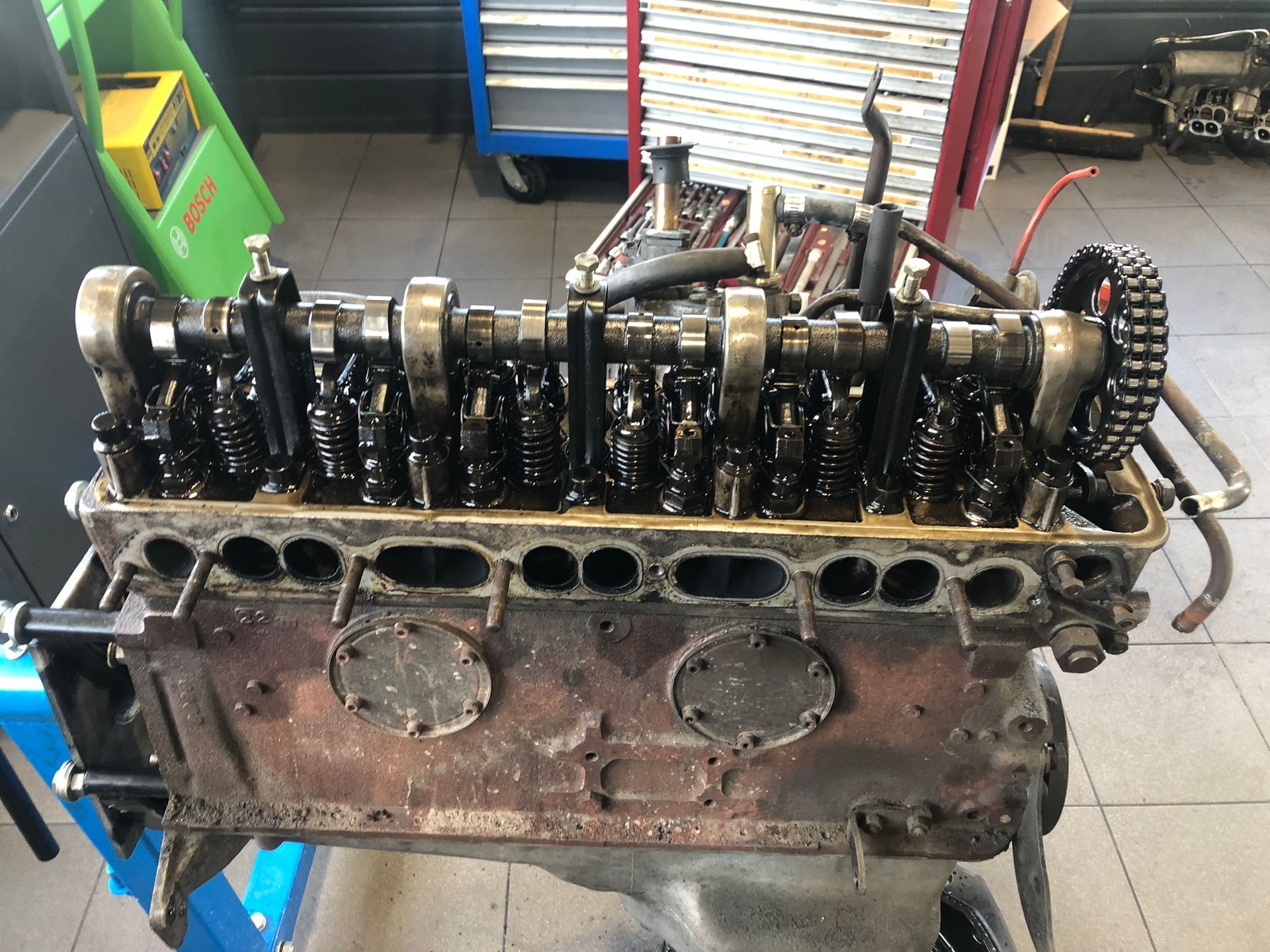 Un moteur de voiture est posé sur une table dans un garage.