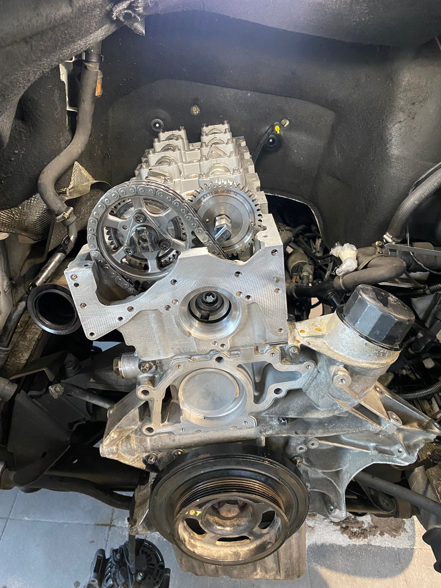 Un moteur de voiture est posé sur une table en bois.