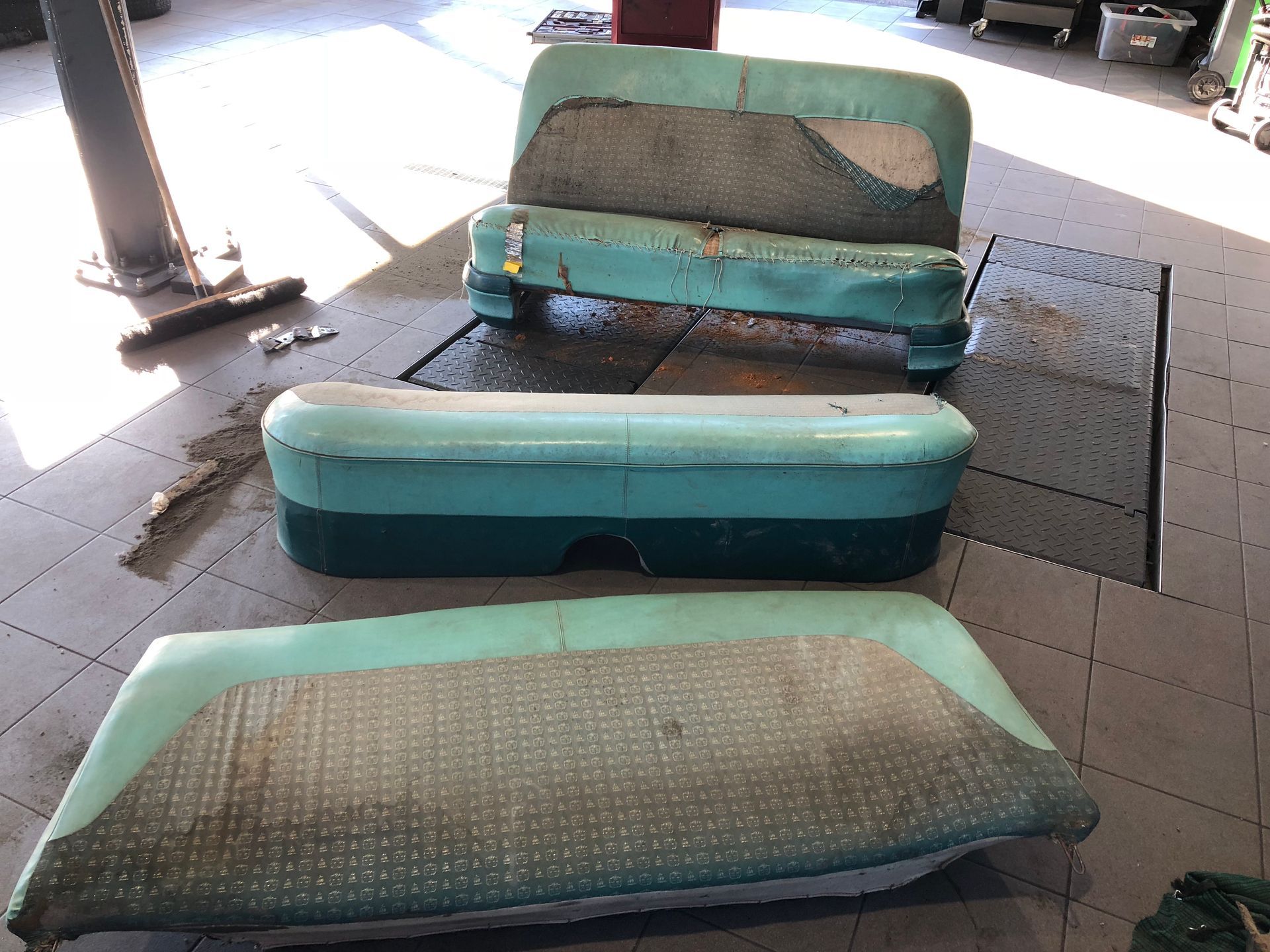 Un canapé est posé sur le carrelage d'un garage.